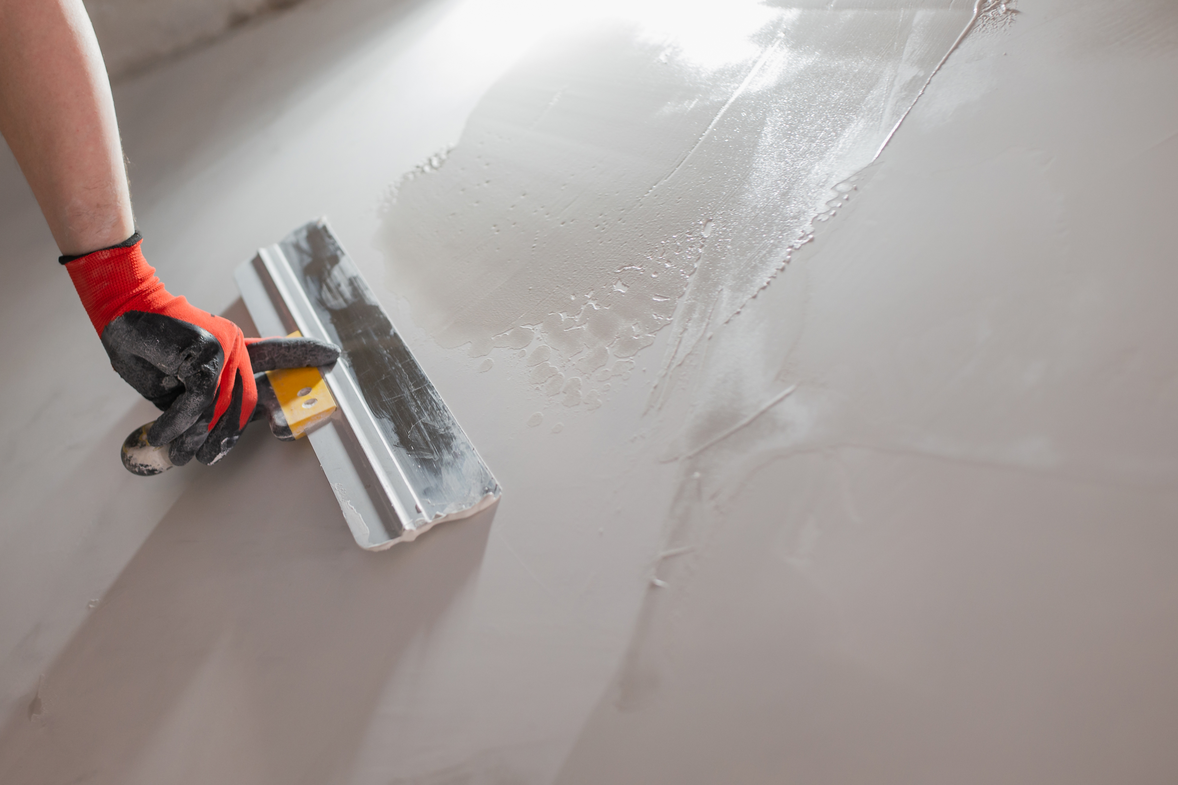 Close-up of a spatula working on drywall