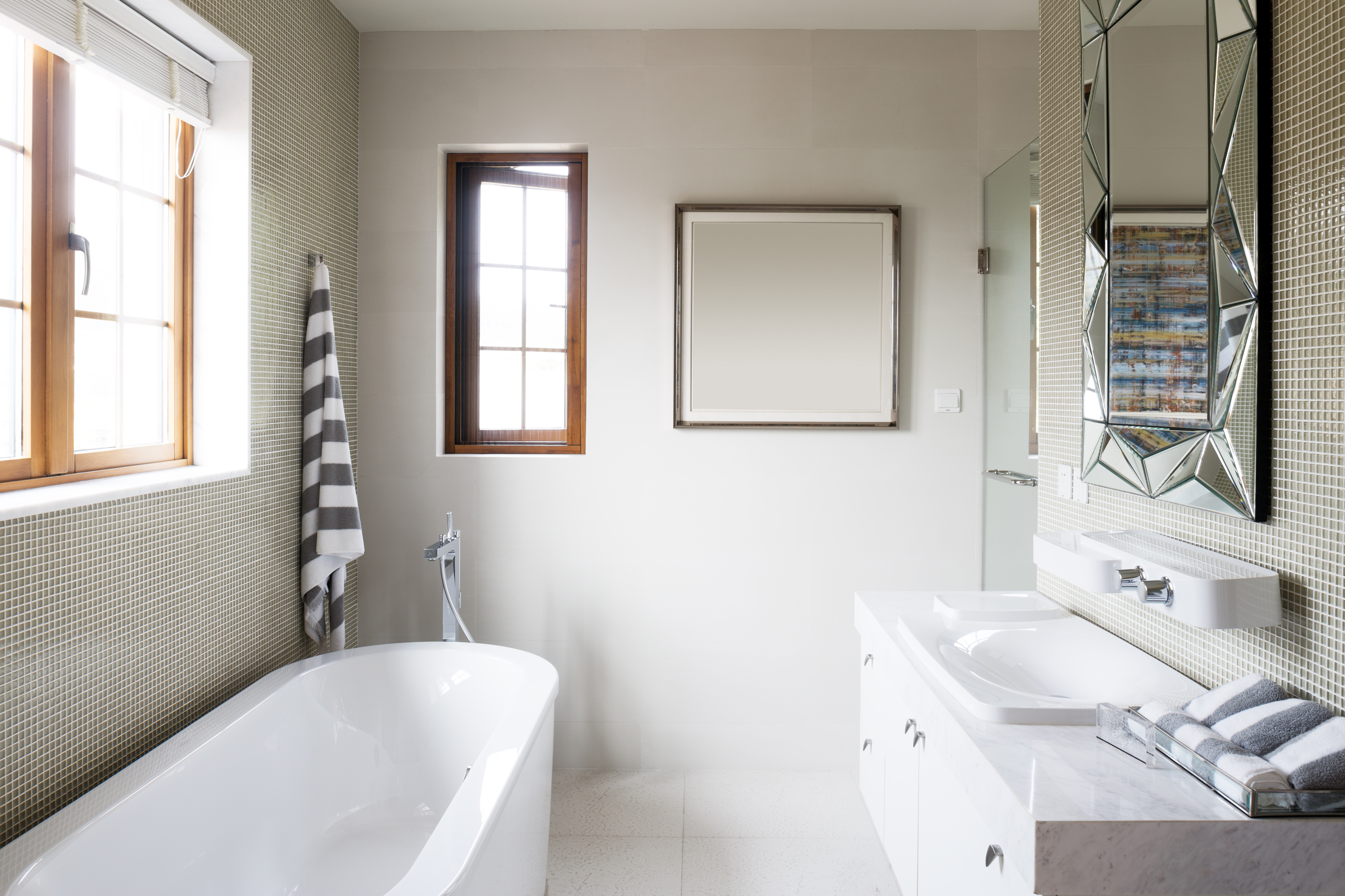 A bright bathroom with a white bathtub