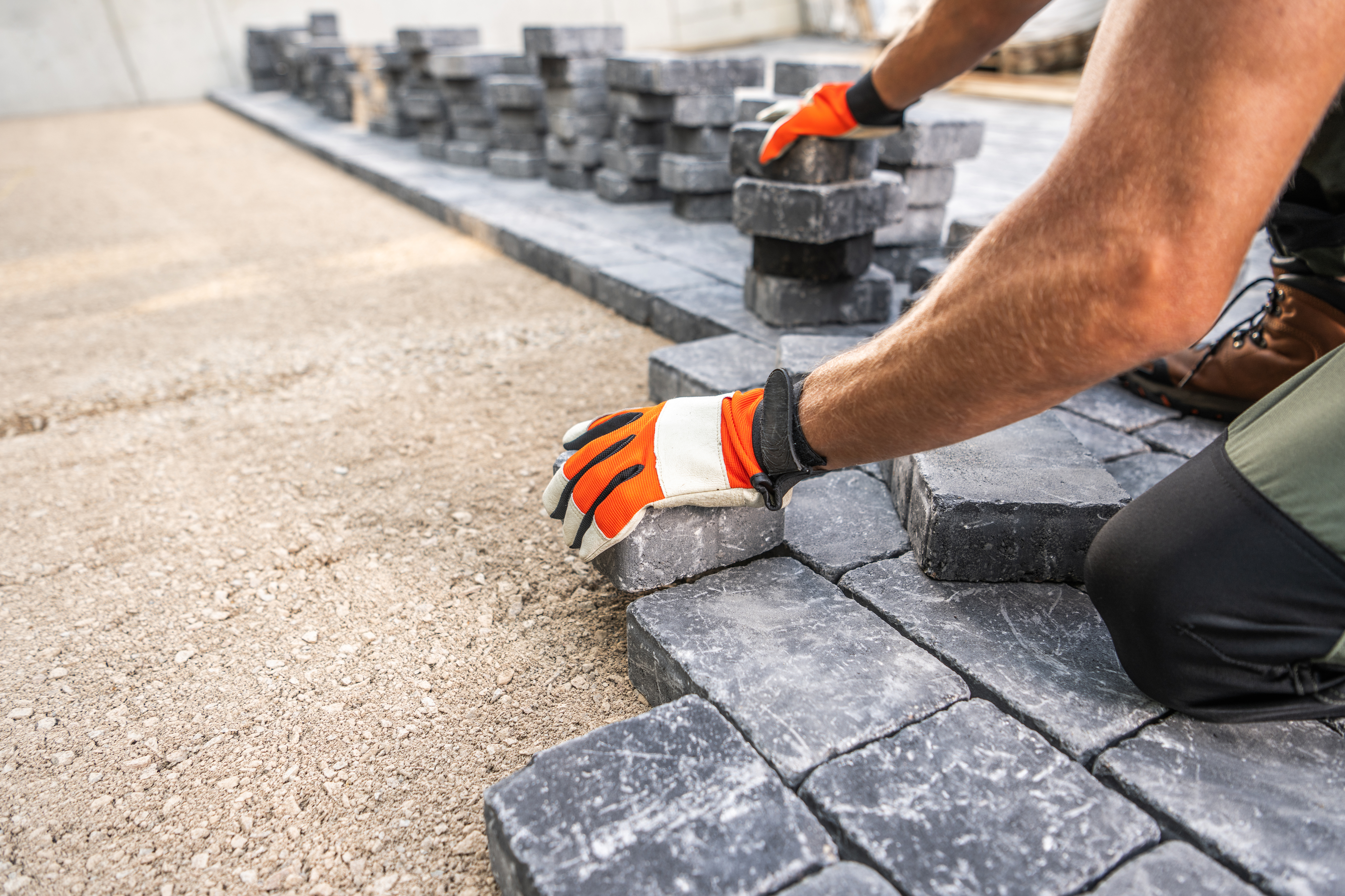 Worker laying paving stones