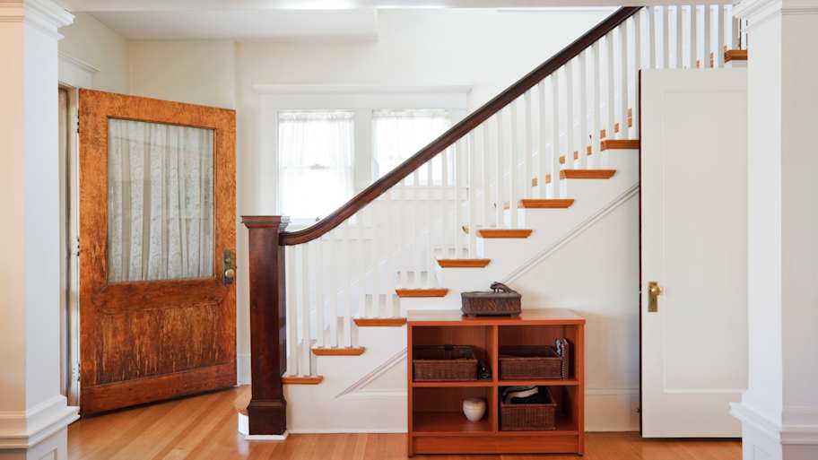 An entryway with white and wood staircase