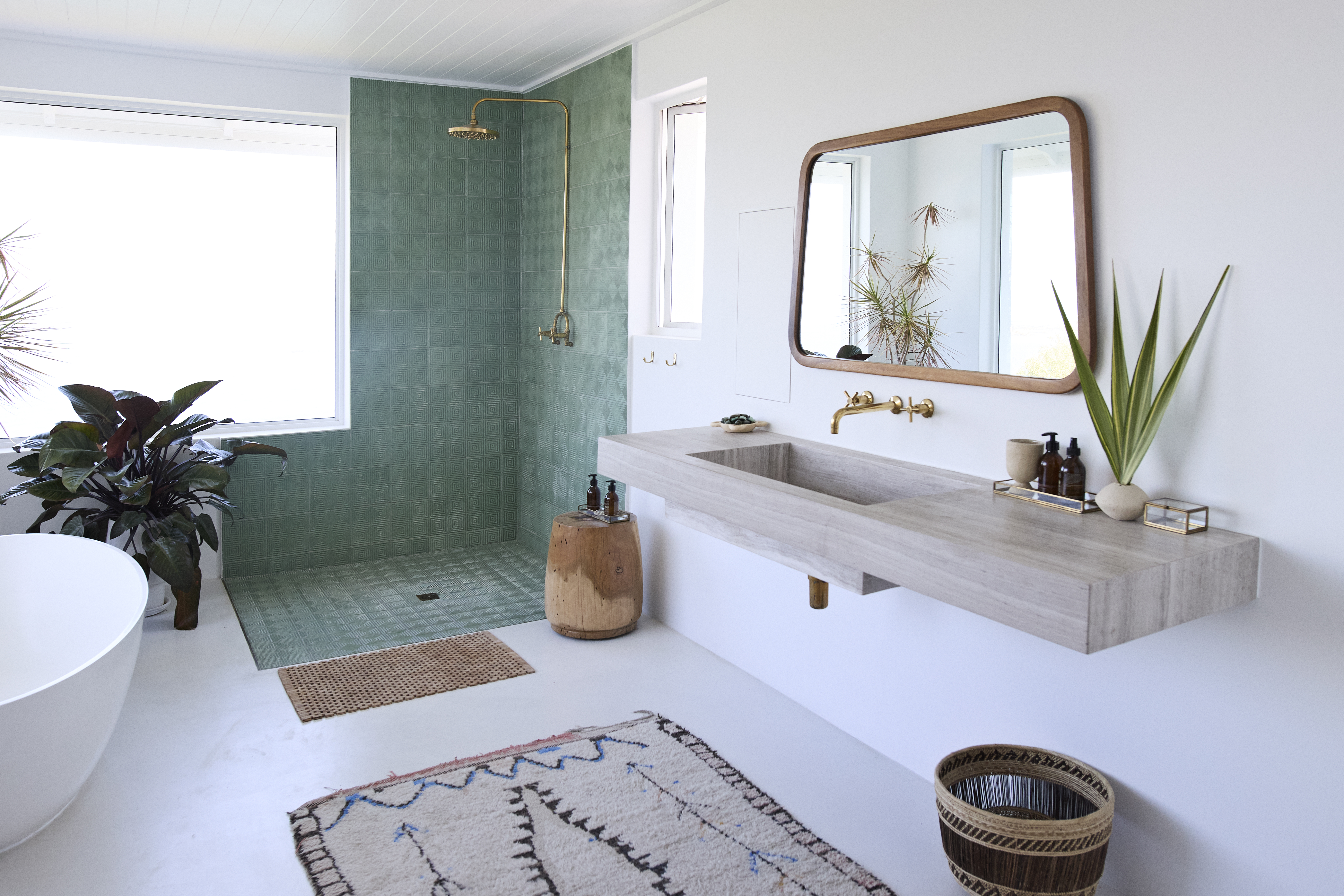 Doorless walk-in shower with green tiles on the floor and walls 