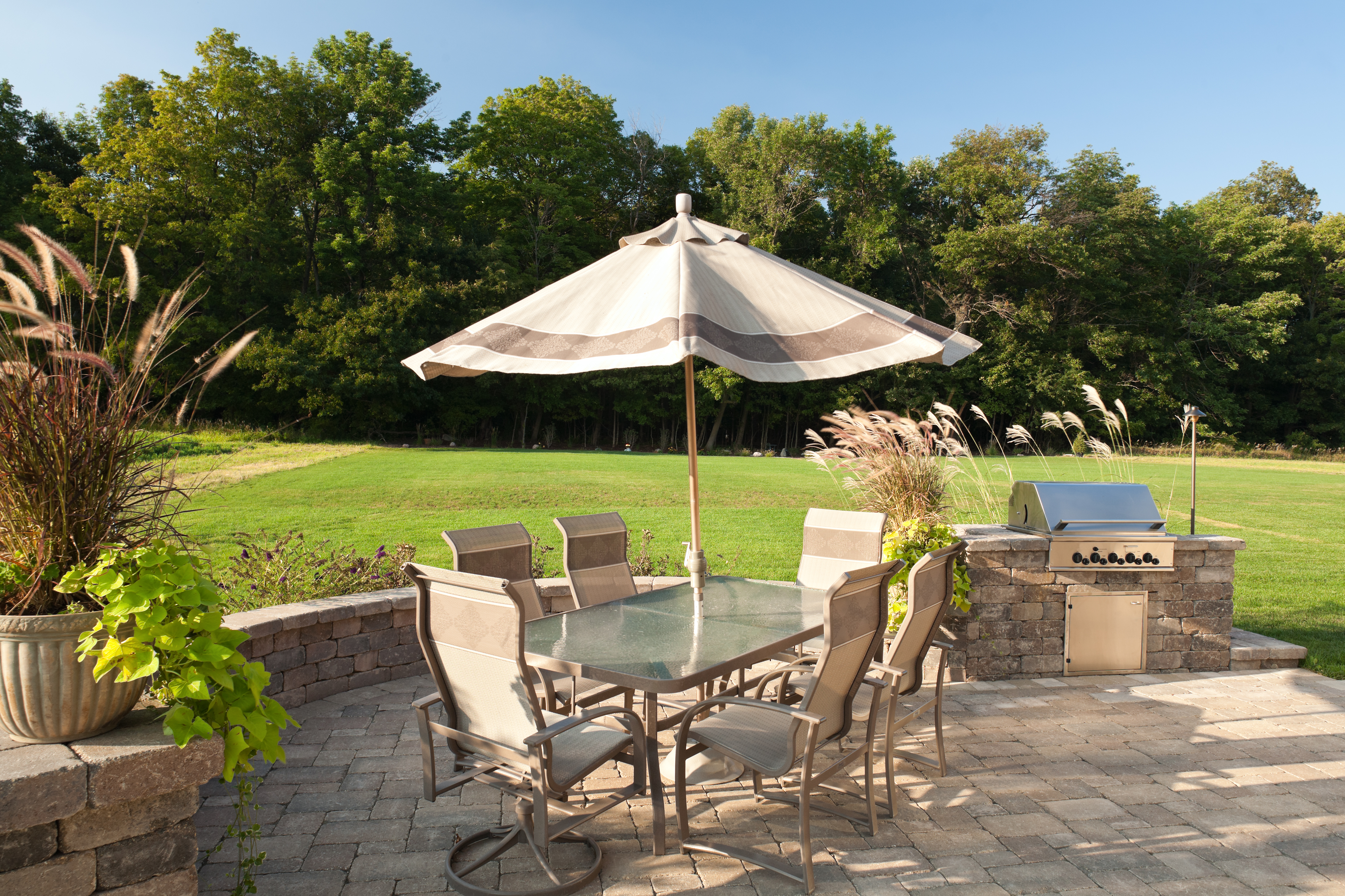 Backyard patio with outdoor table and a BBQ grill