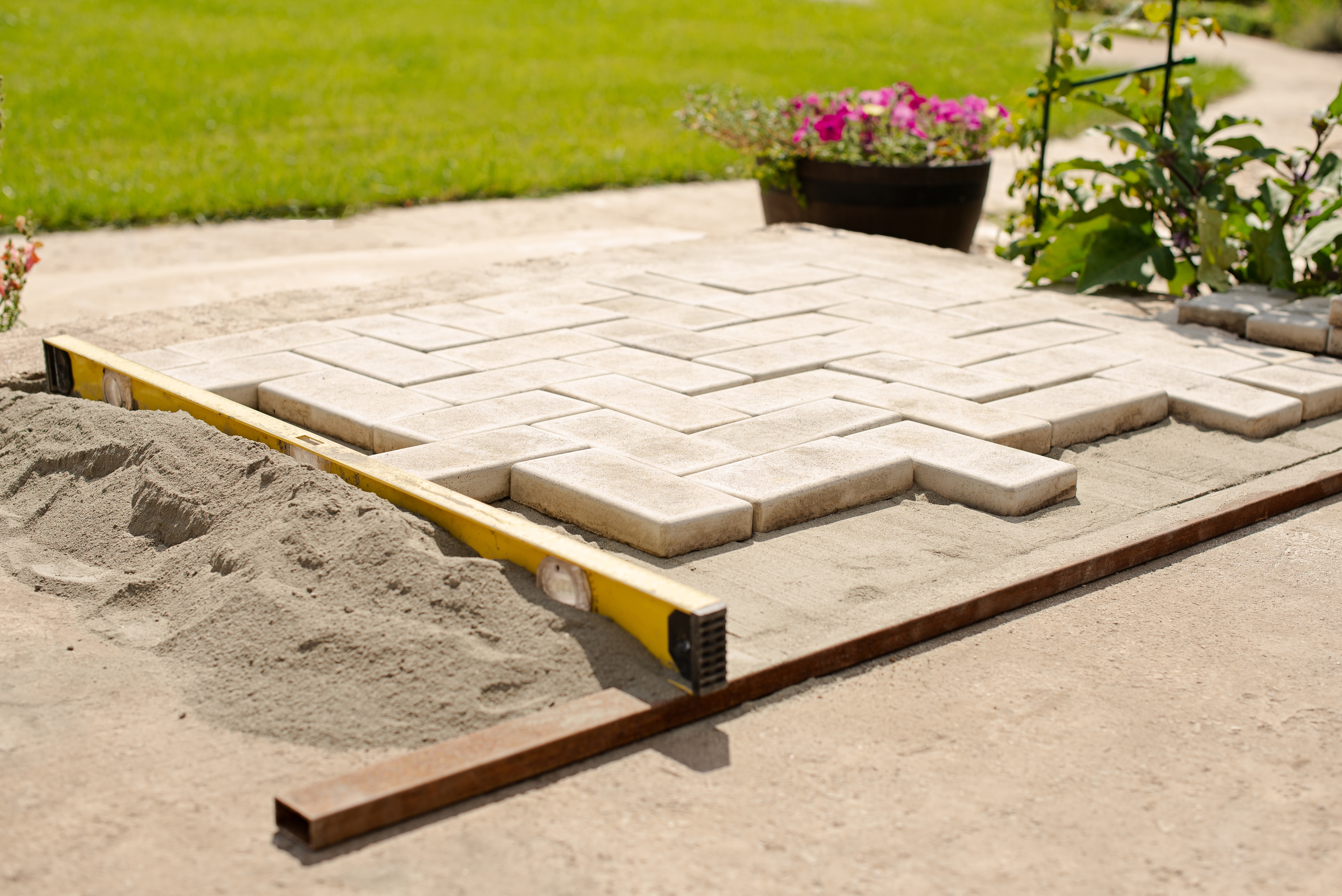 New patio pavers installed on top of a sand layer
