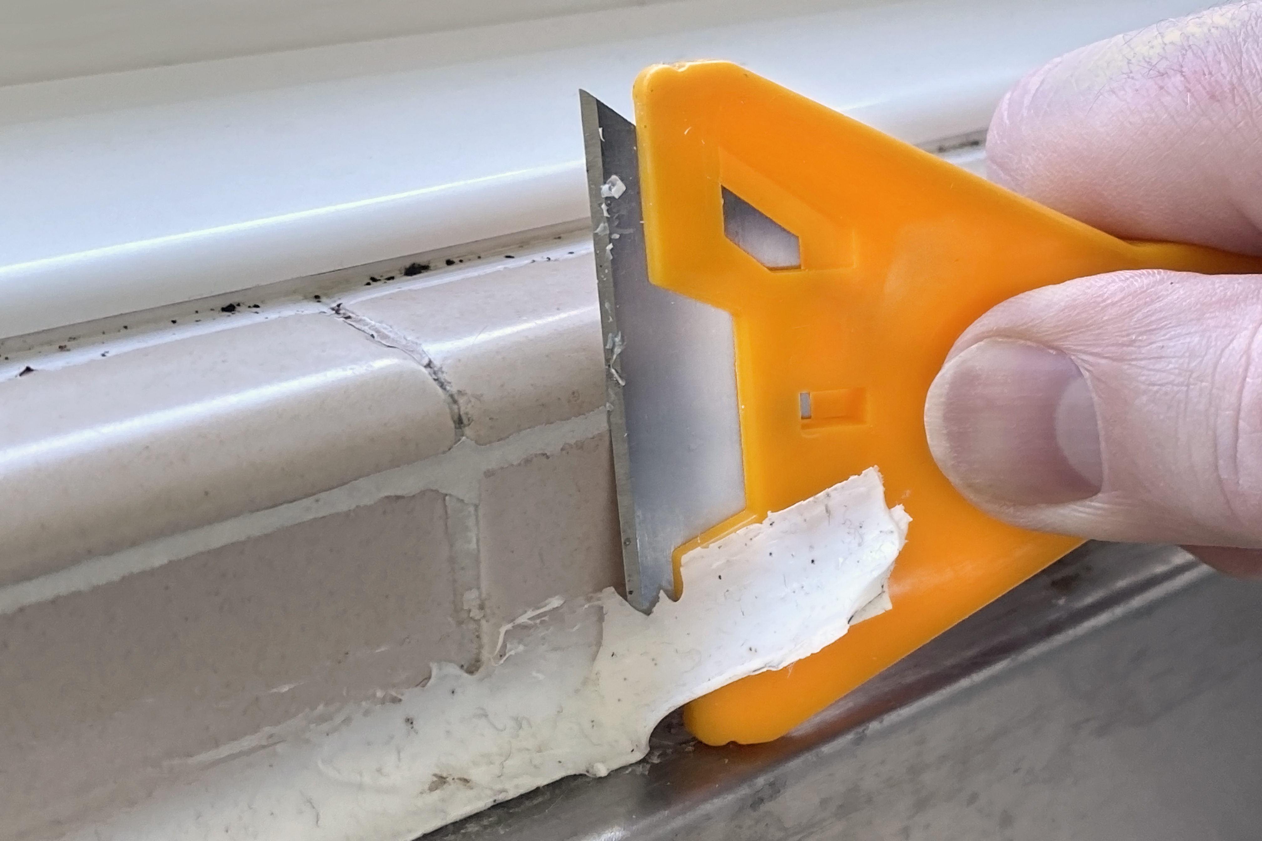 Scraping off old caulk from the shower