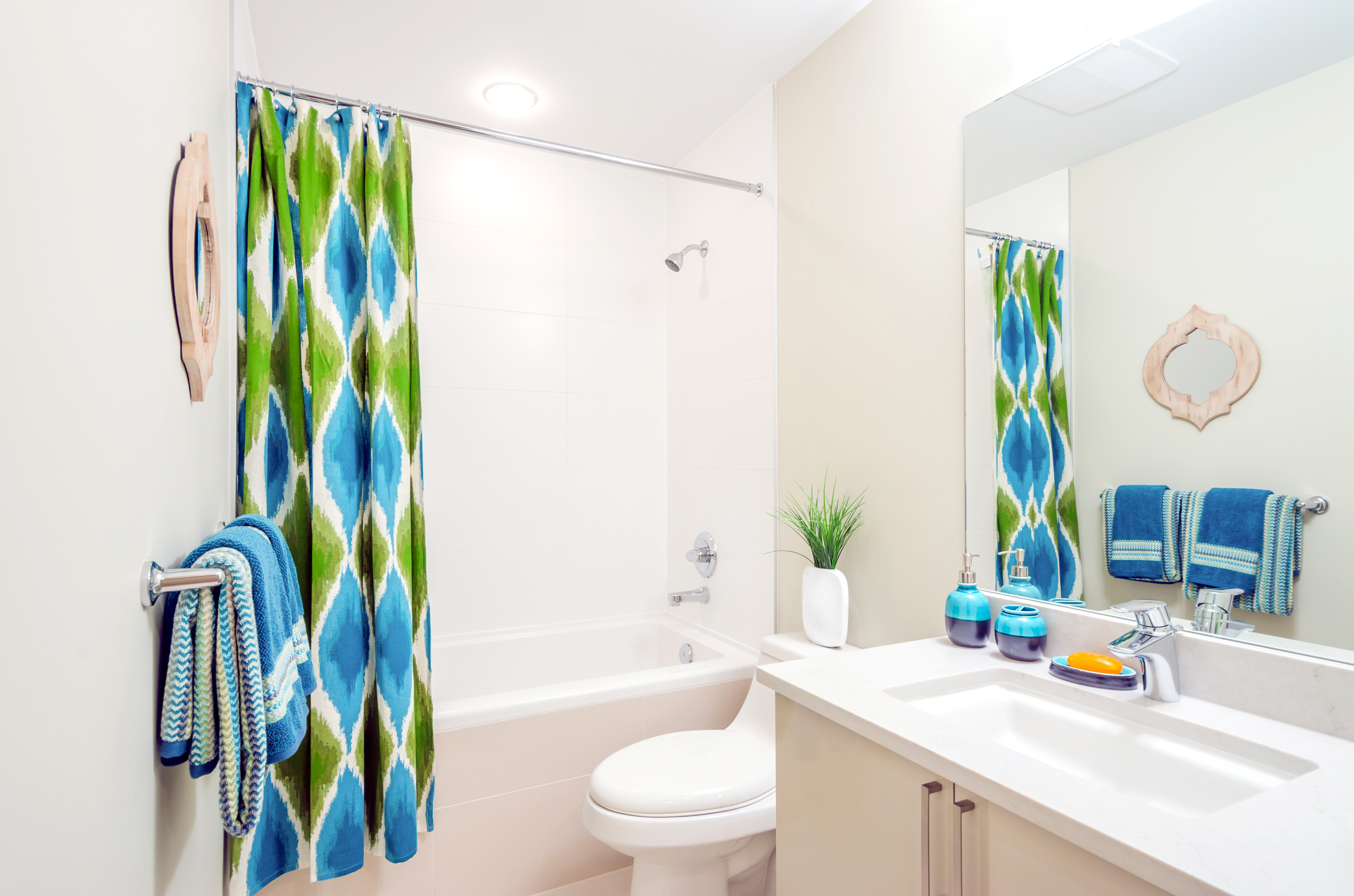 Green and blue shower curtain installed in the bathroom