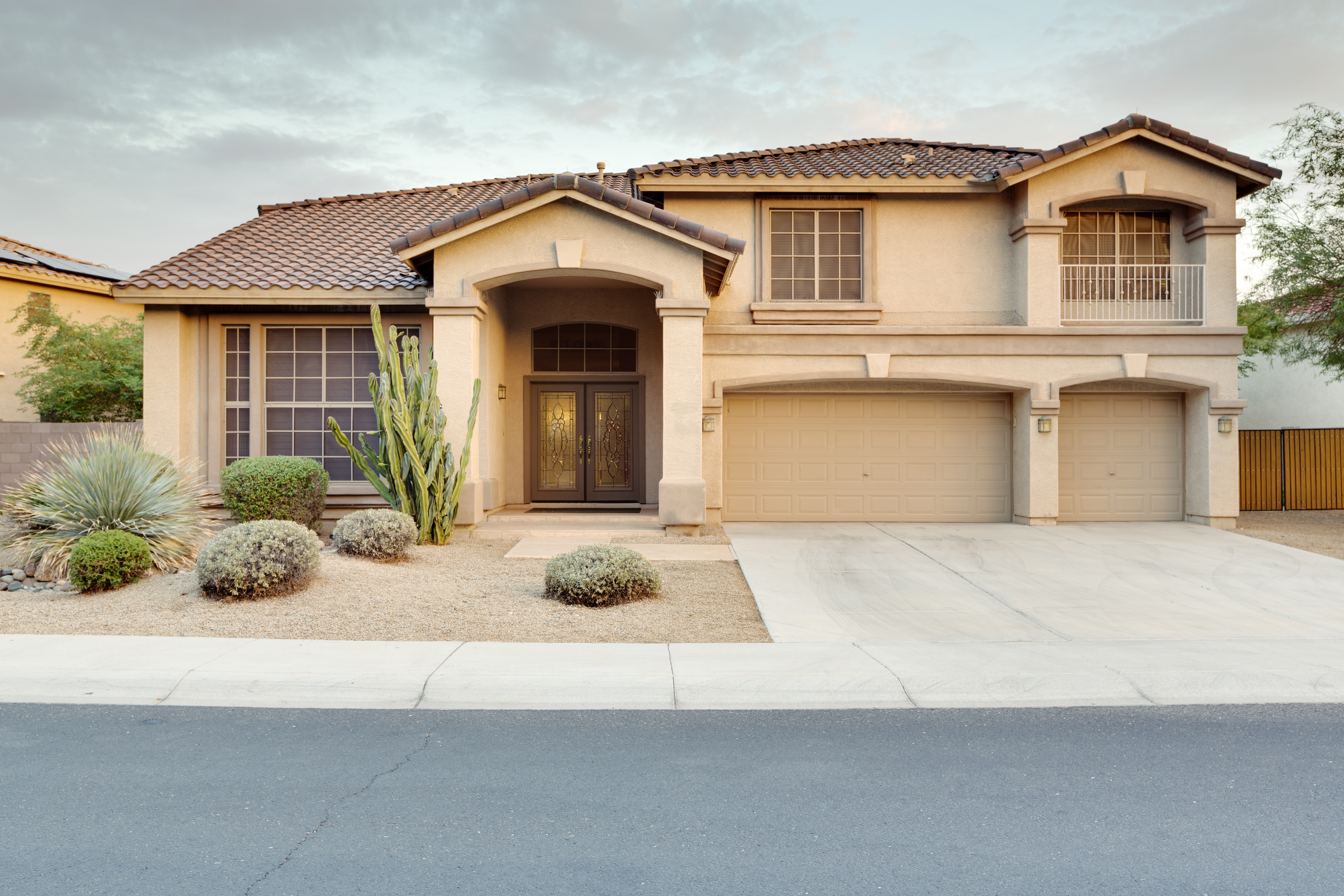 Large home exterior with stucco siding and tile roof