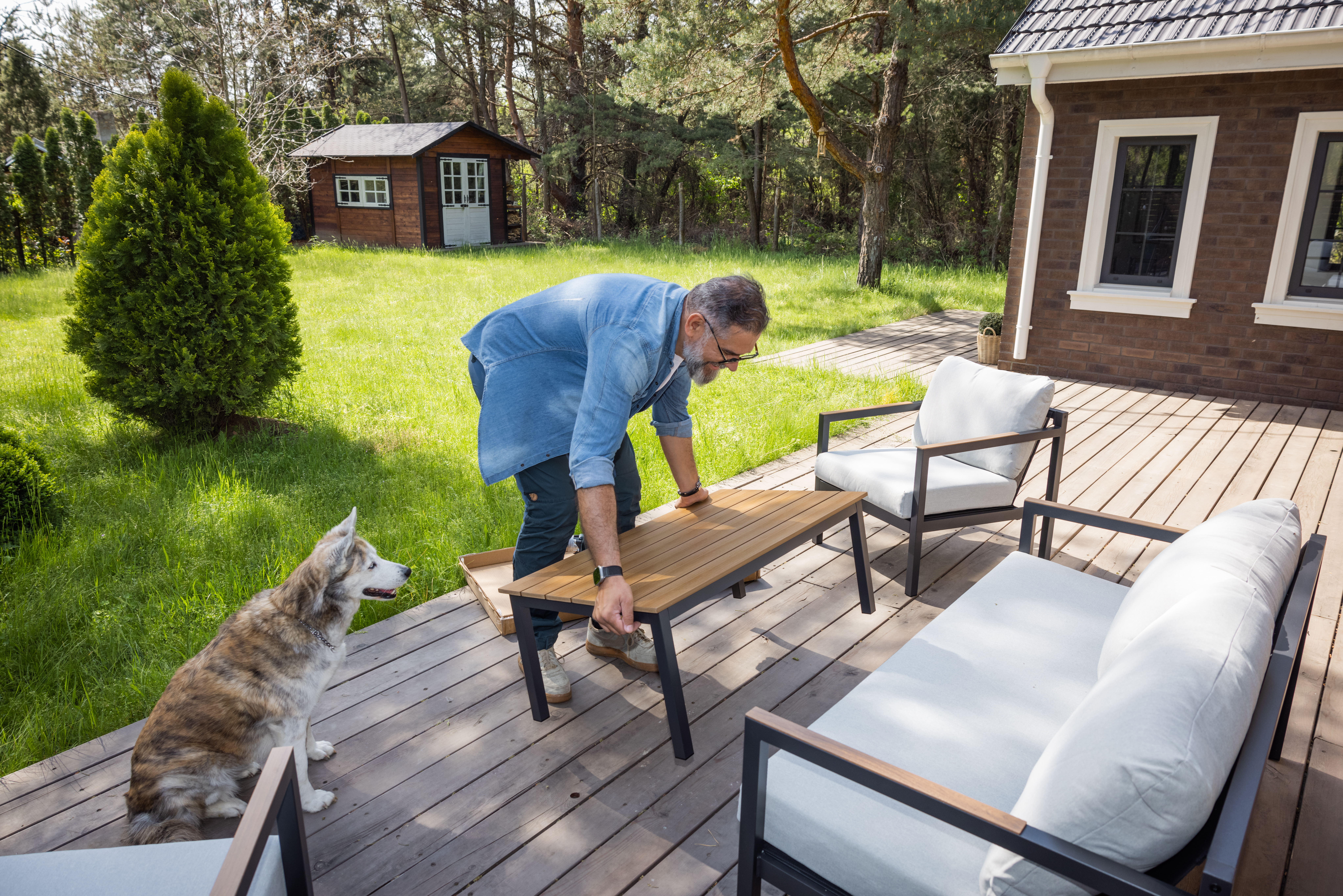 A man placing furniture on the patio