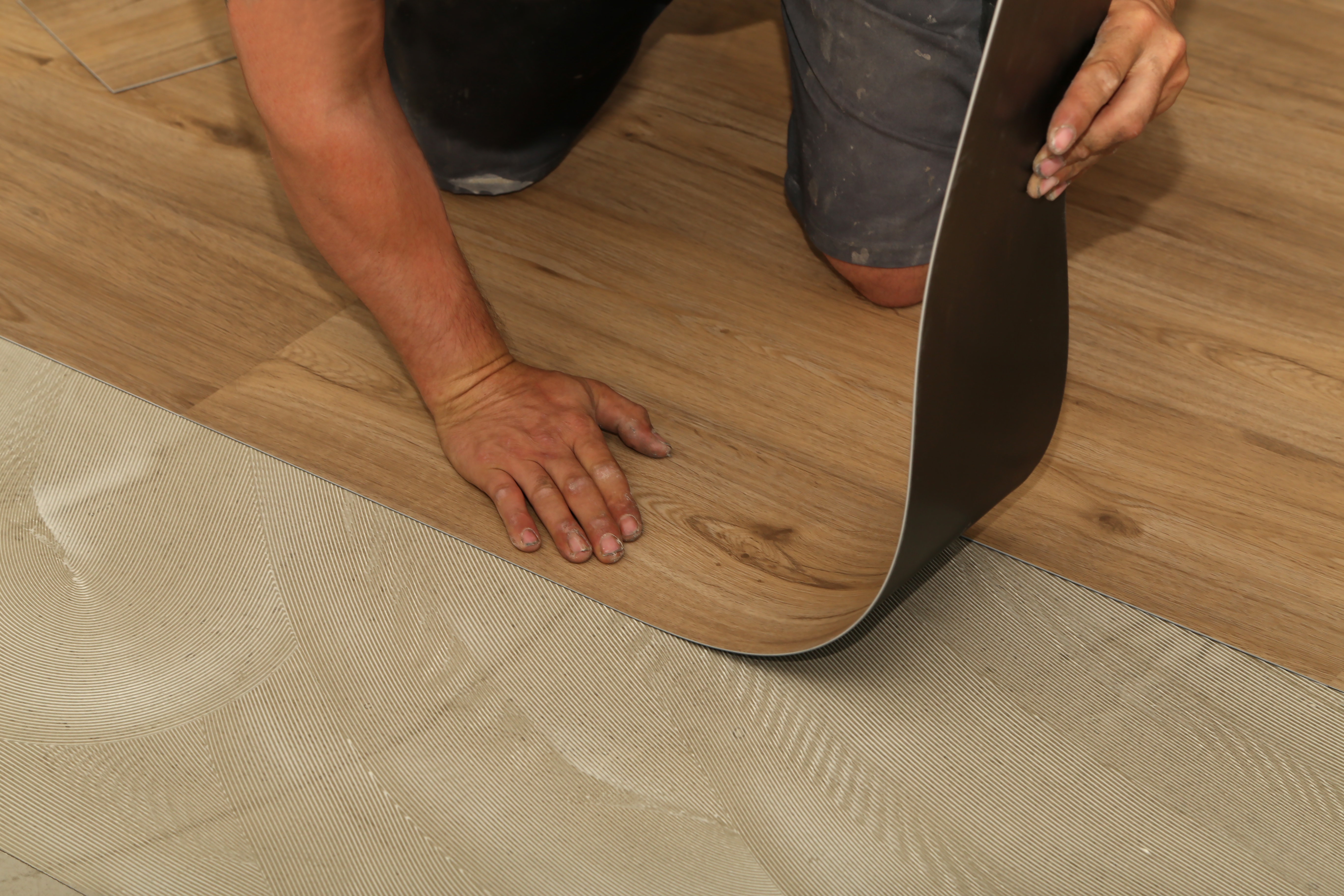 A man installing vinyl flooring