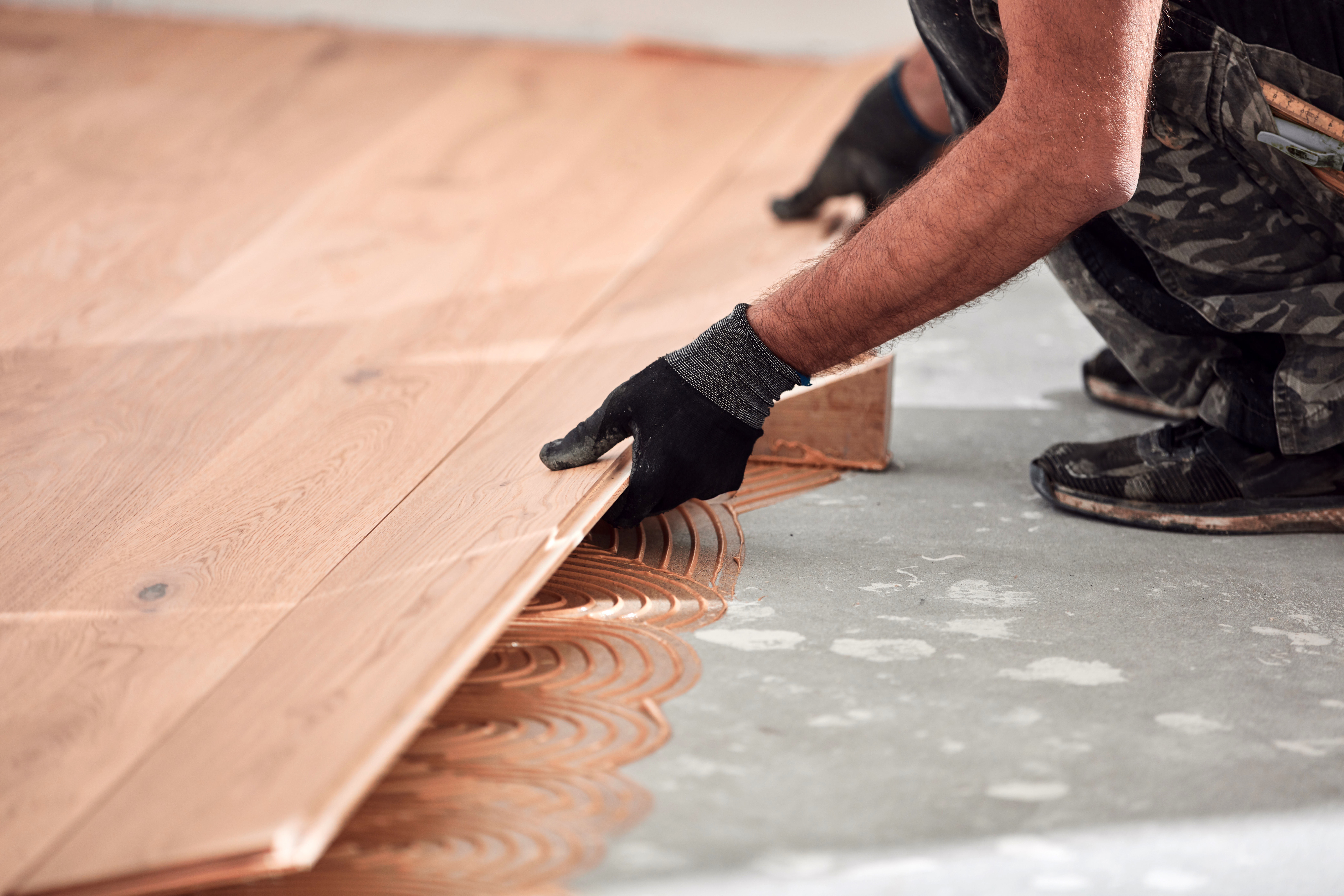 A person installing engineered hardwood flooring