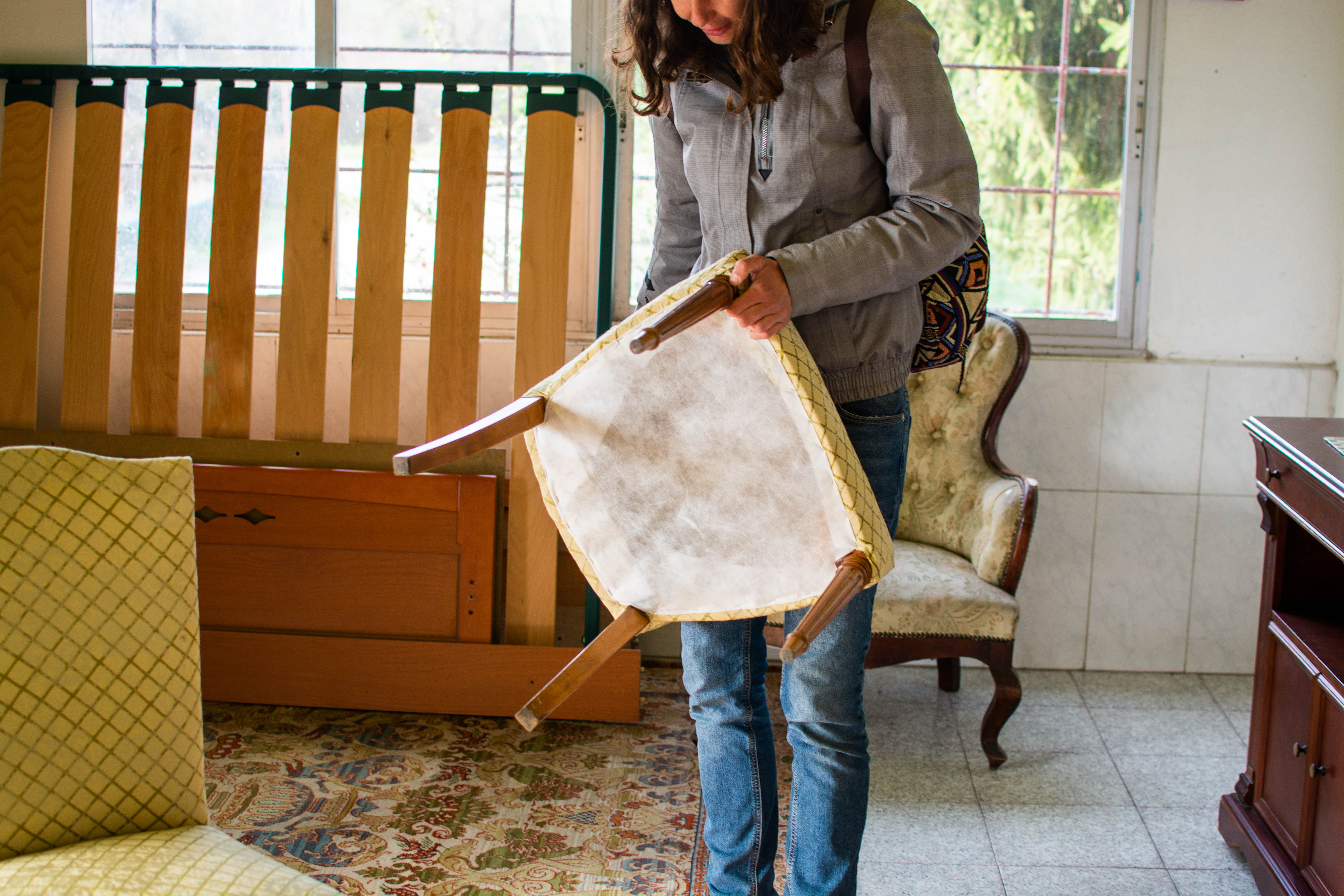 A woman examining a wooden chair