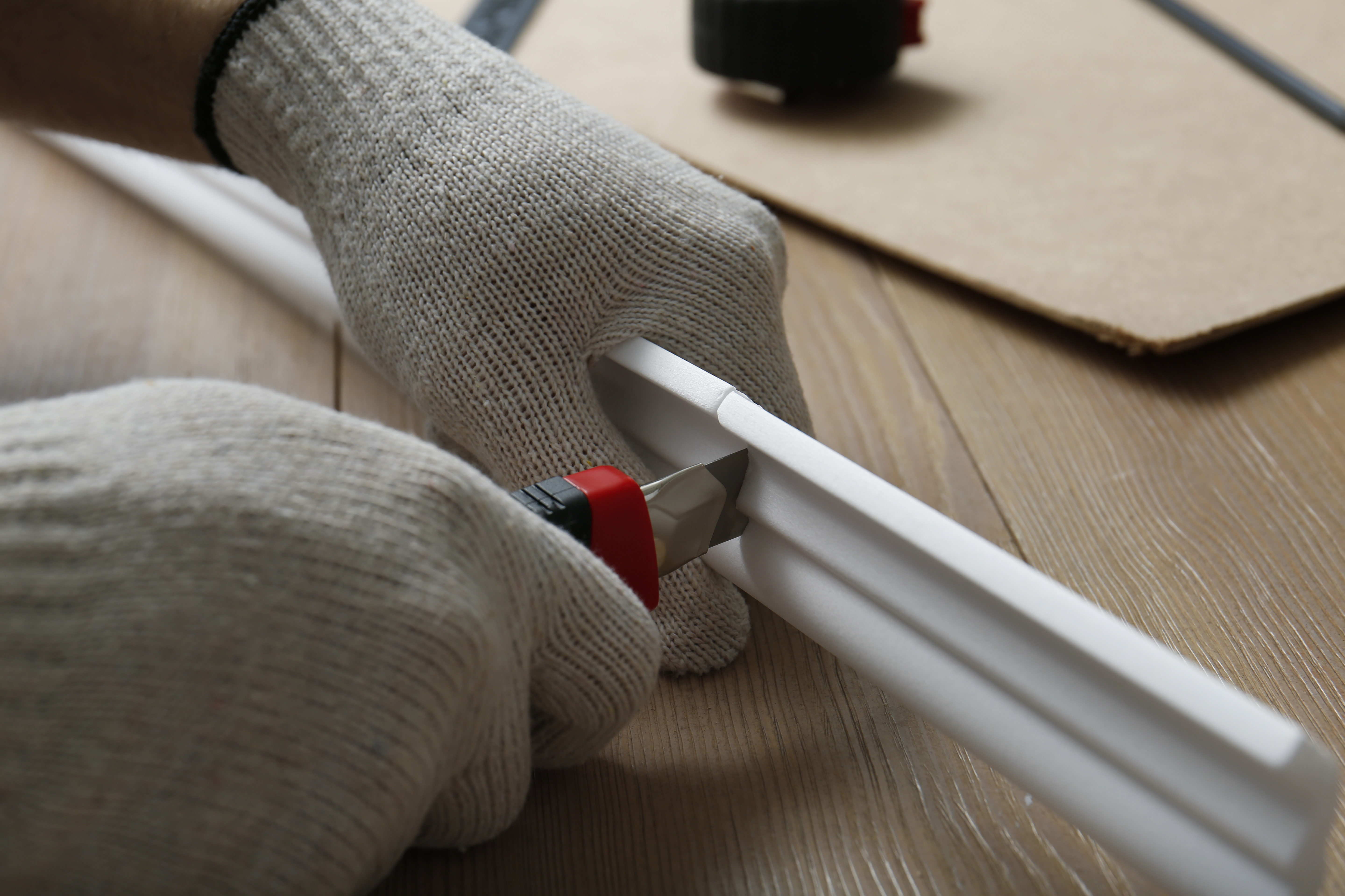A person cutting a foam crown molding 