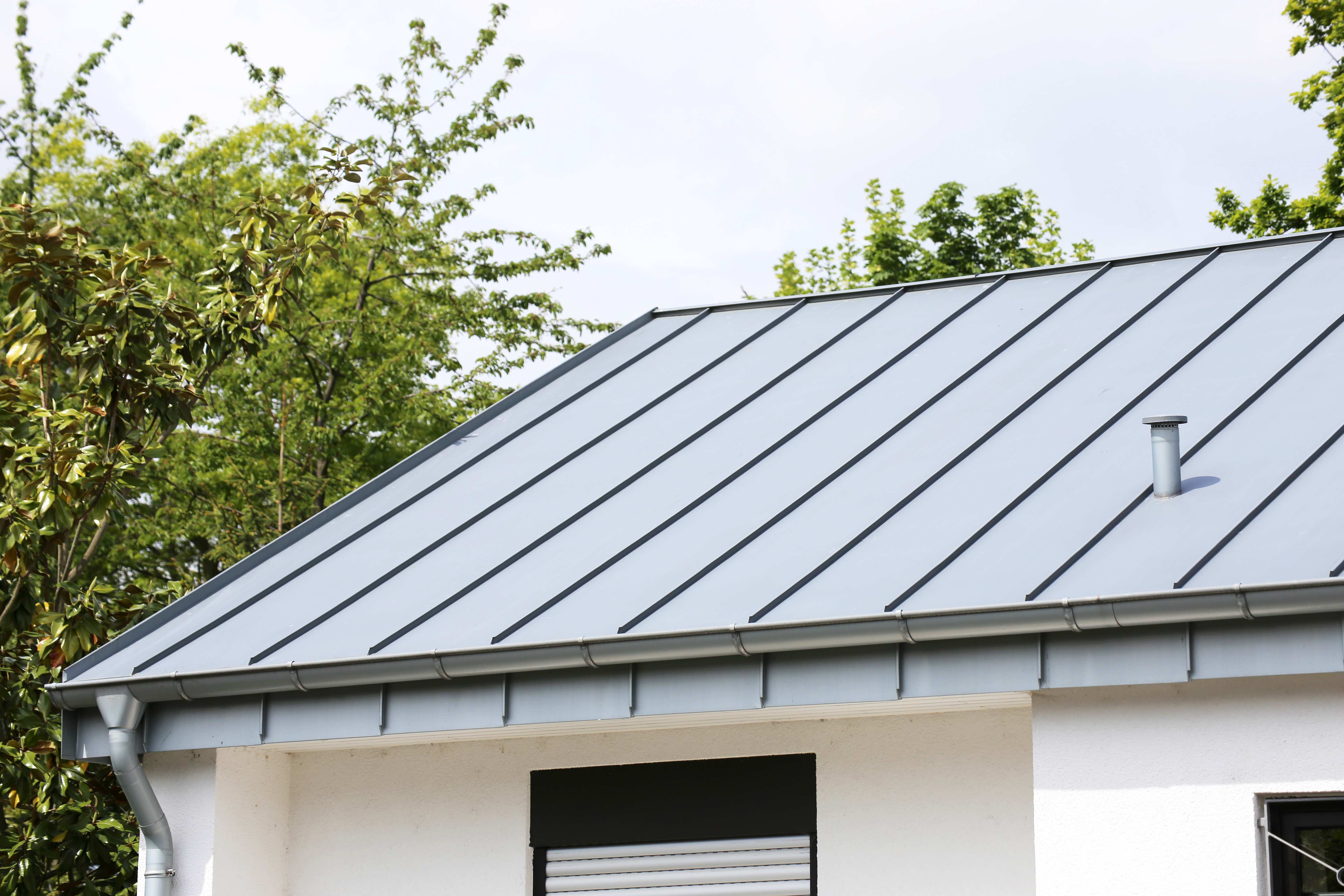 Modern house with a standing seam metal roof and tin gutters  