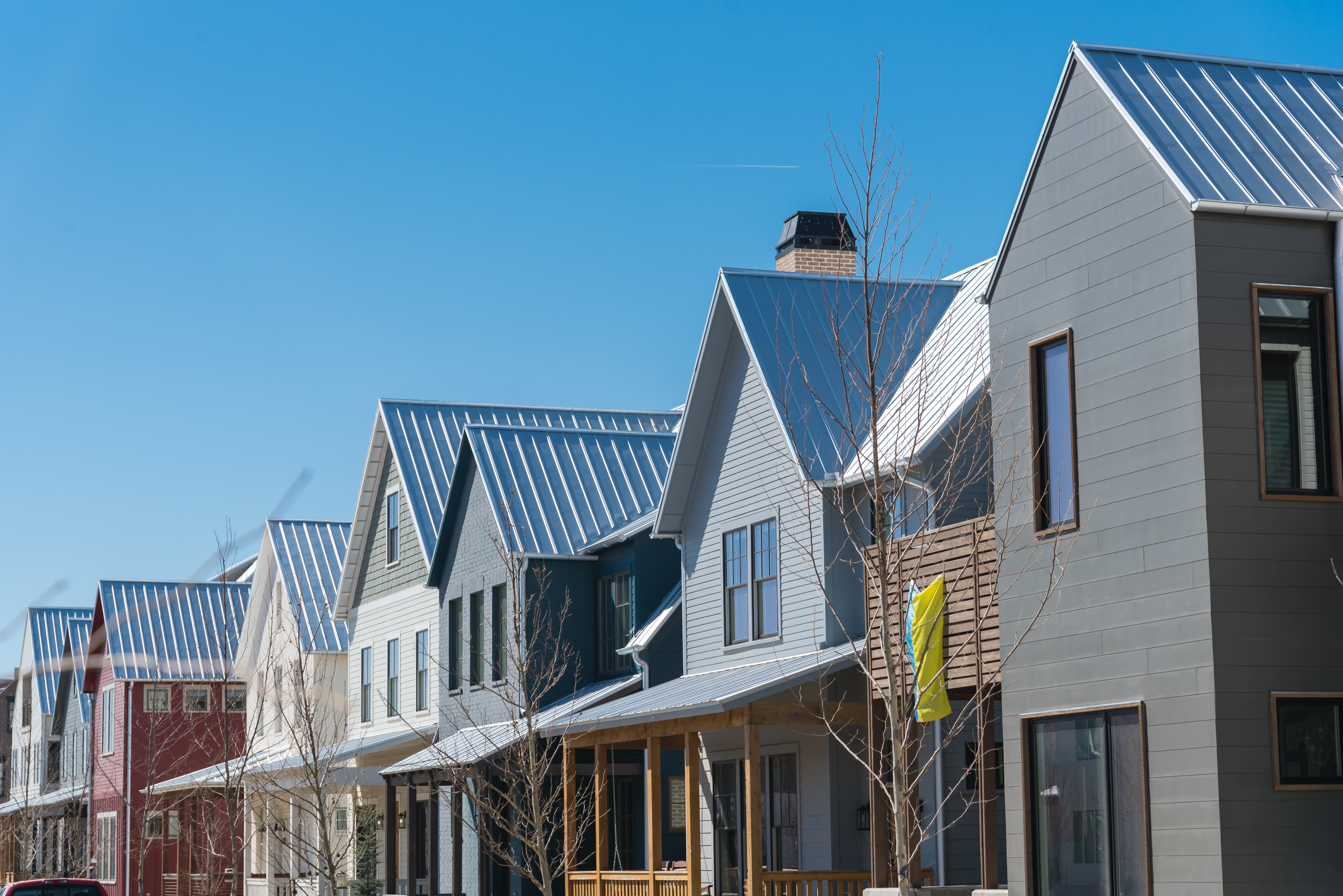 Row of new houses with metal roofs and front porches  