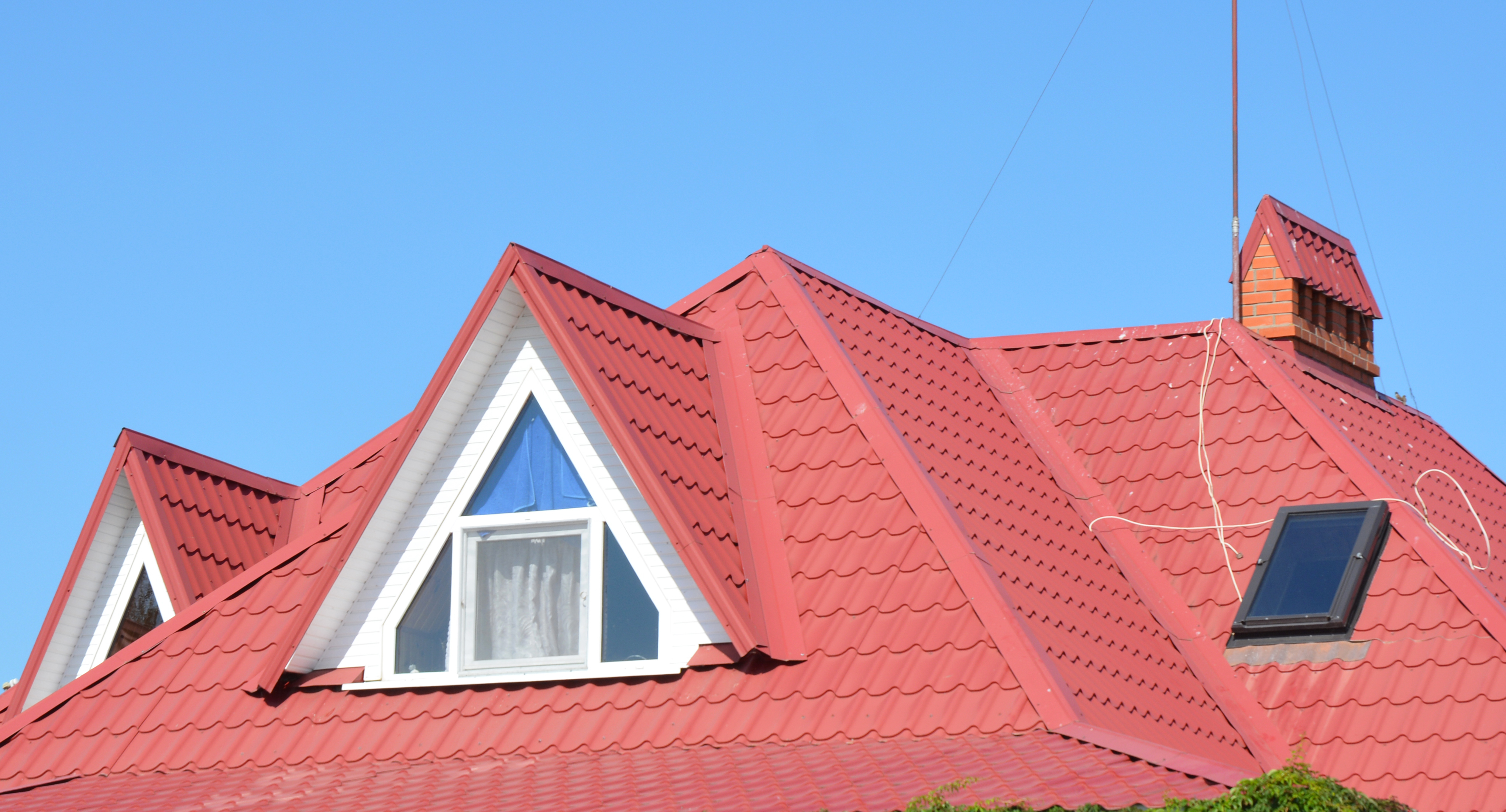 House with red metal roof and dormer windows