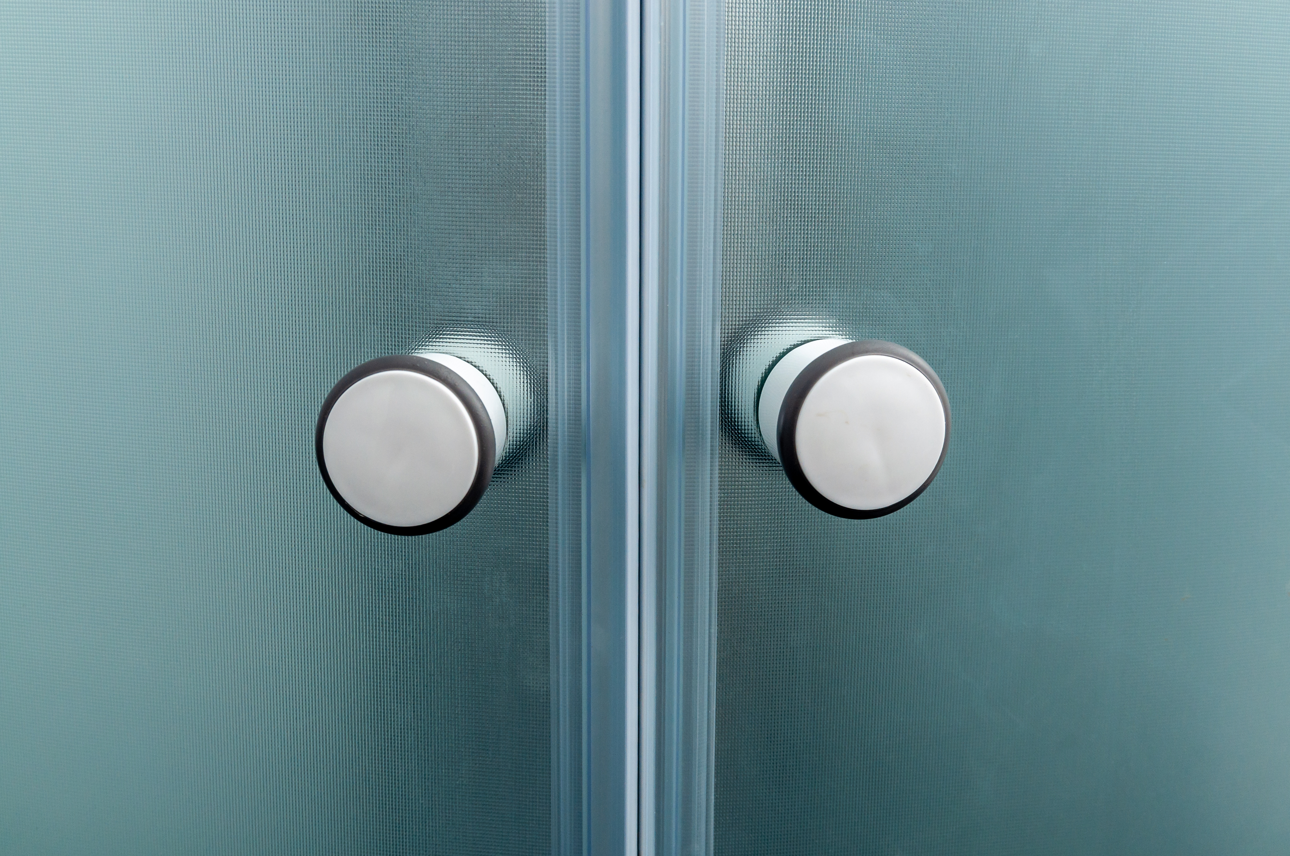 Close up of shower door knobs.