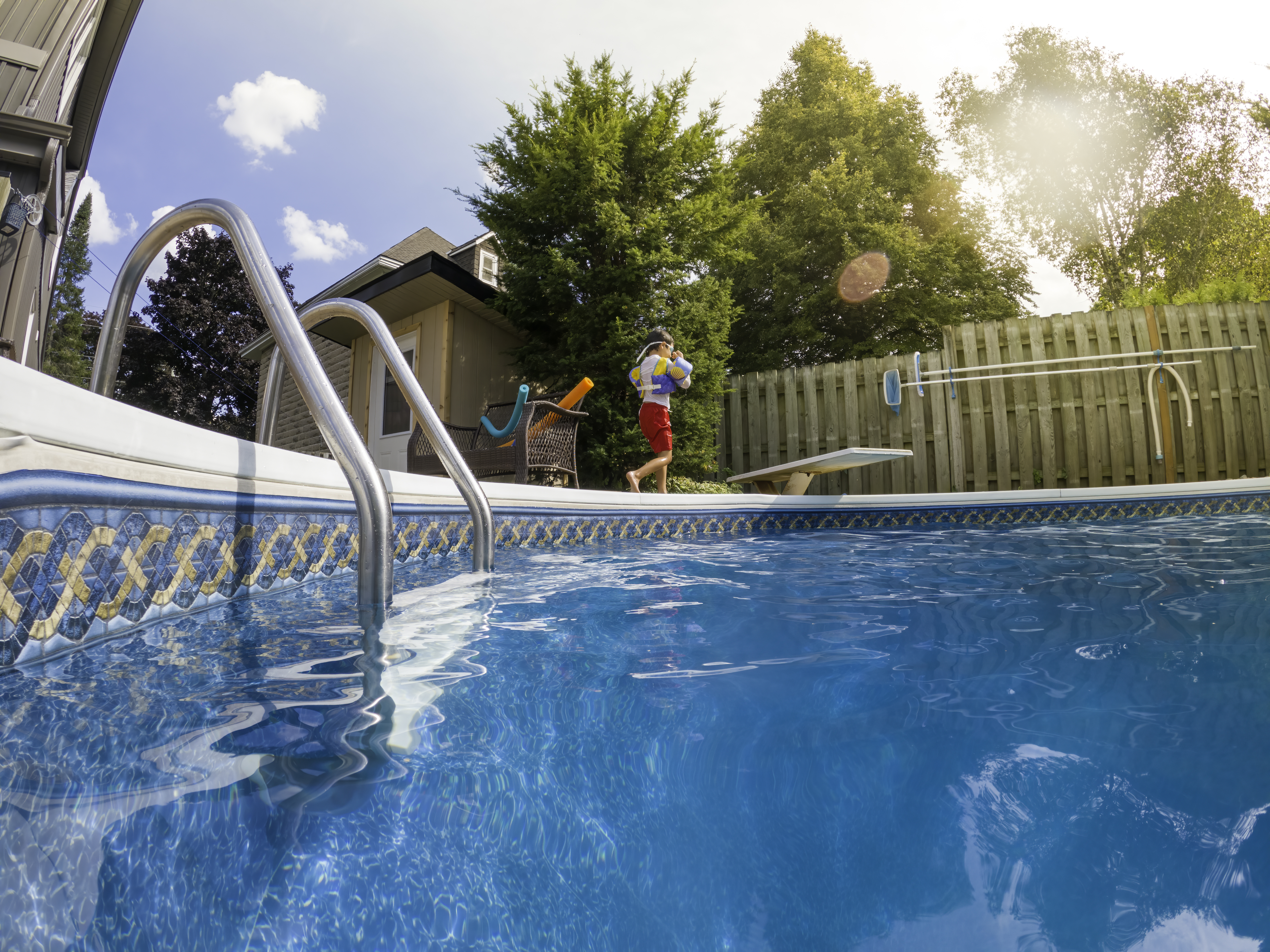 boy walking along pool