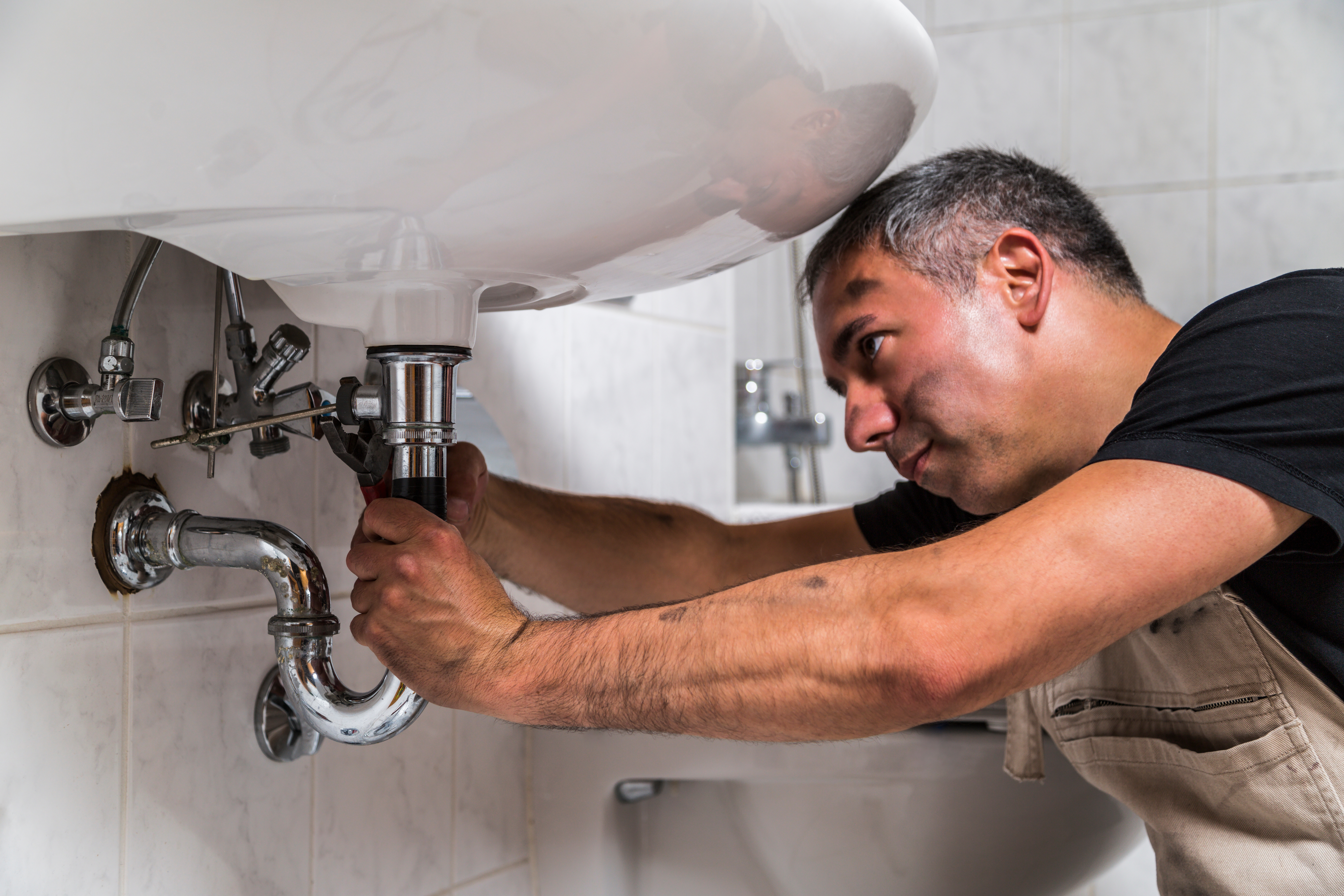 plumber fixing bathroom sink