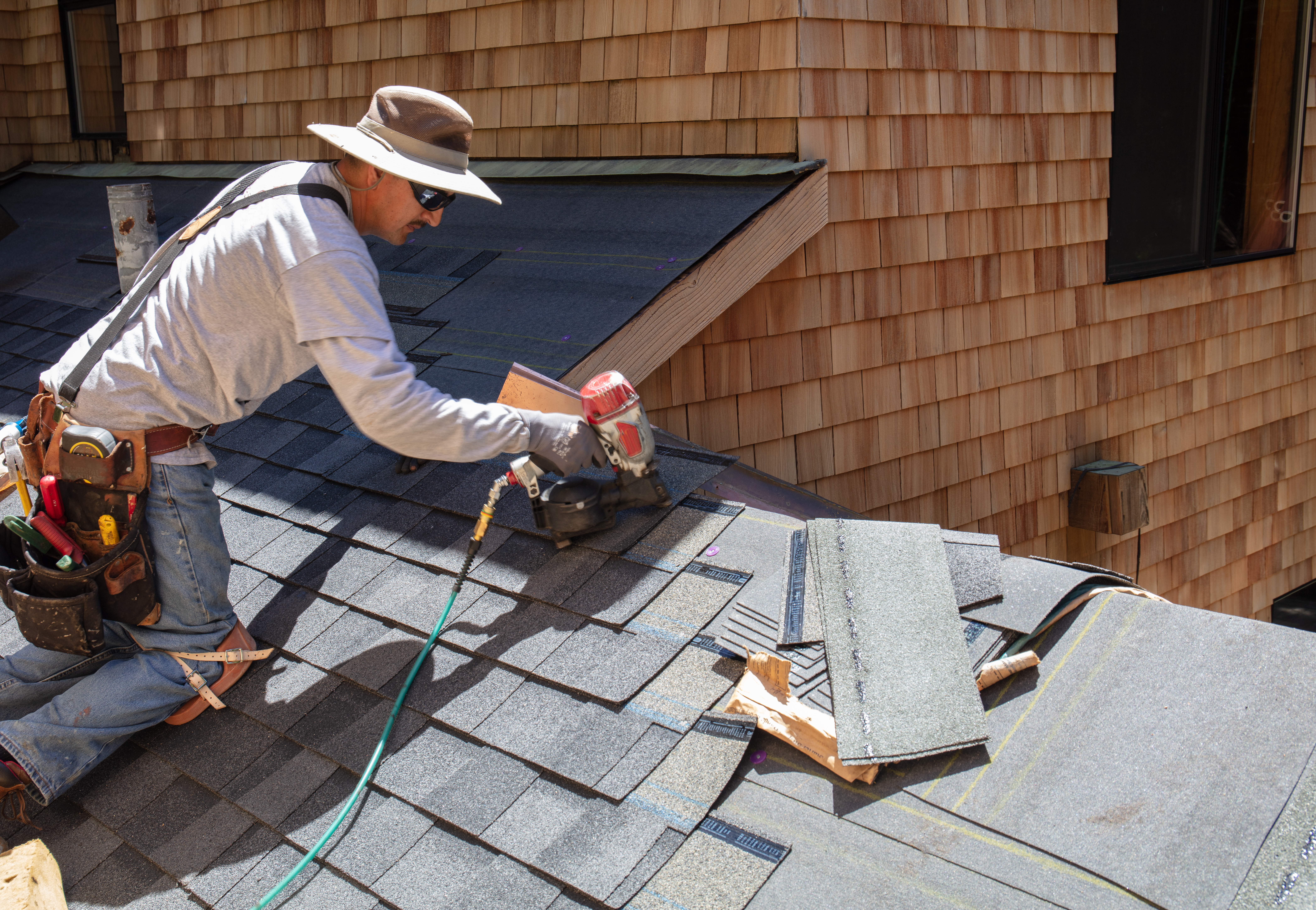 Roofer installing asphalt shingles on the roof 