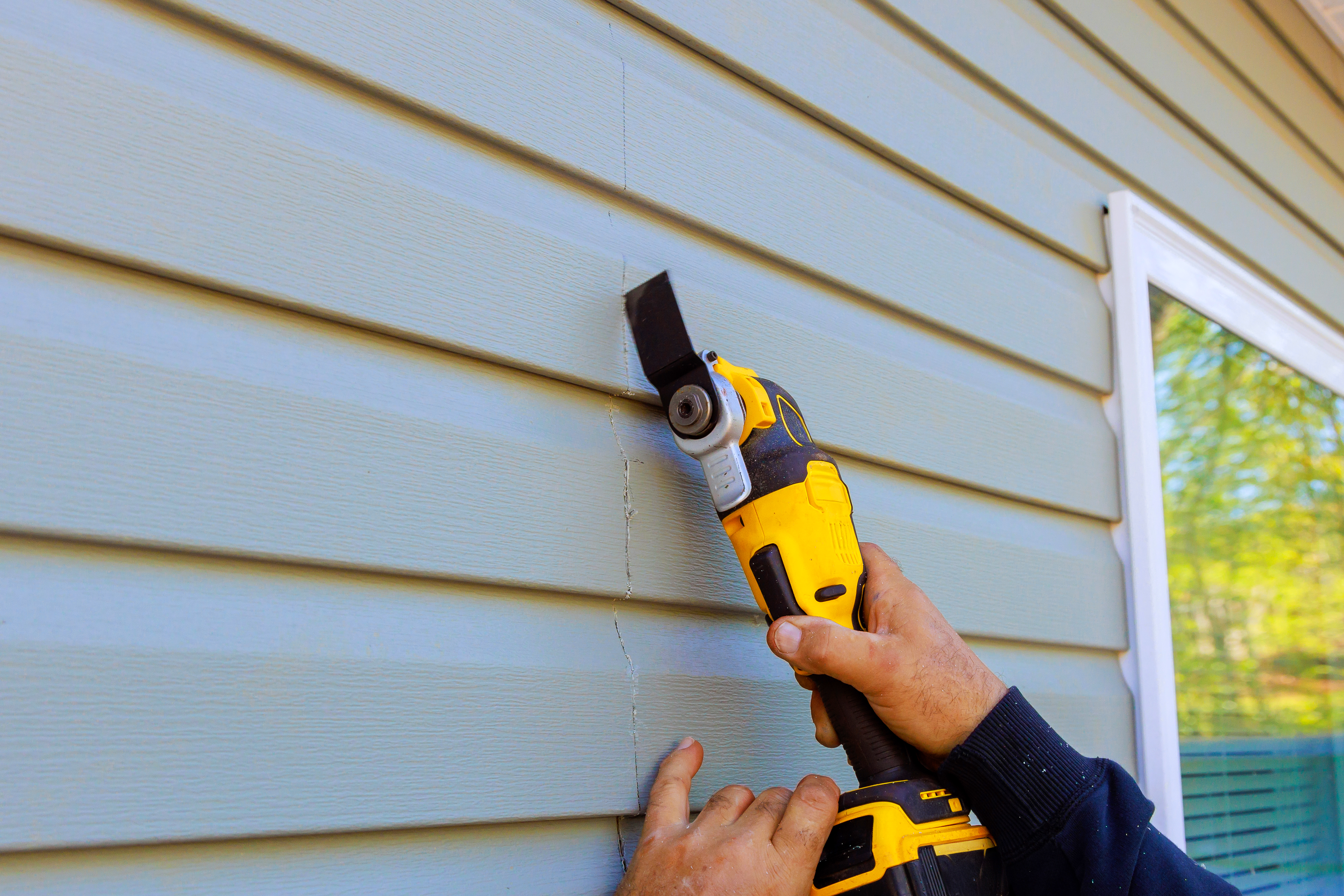 man repairing siding
