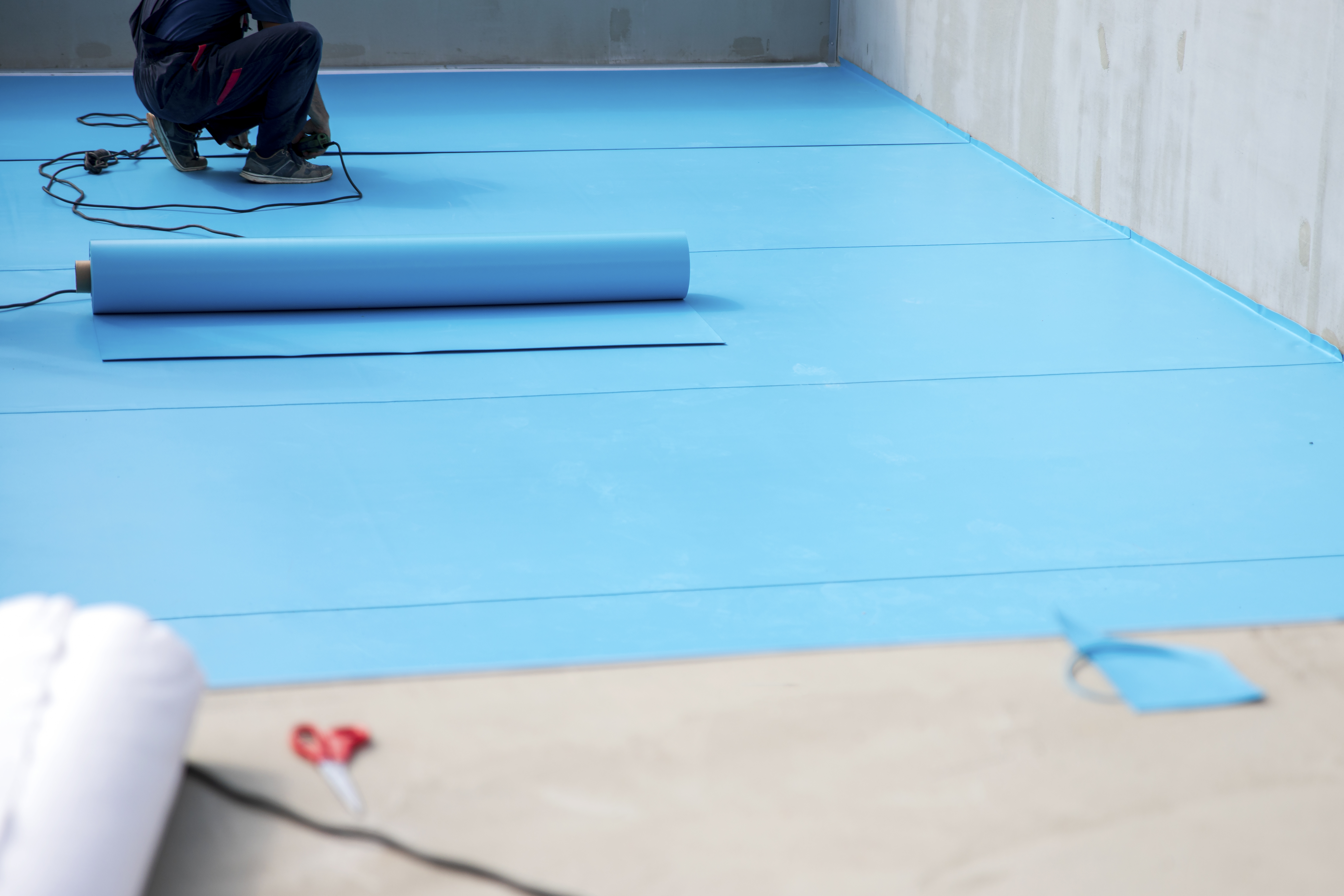 A professional installing a bottom pool liner