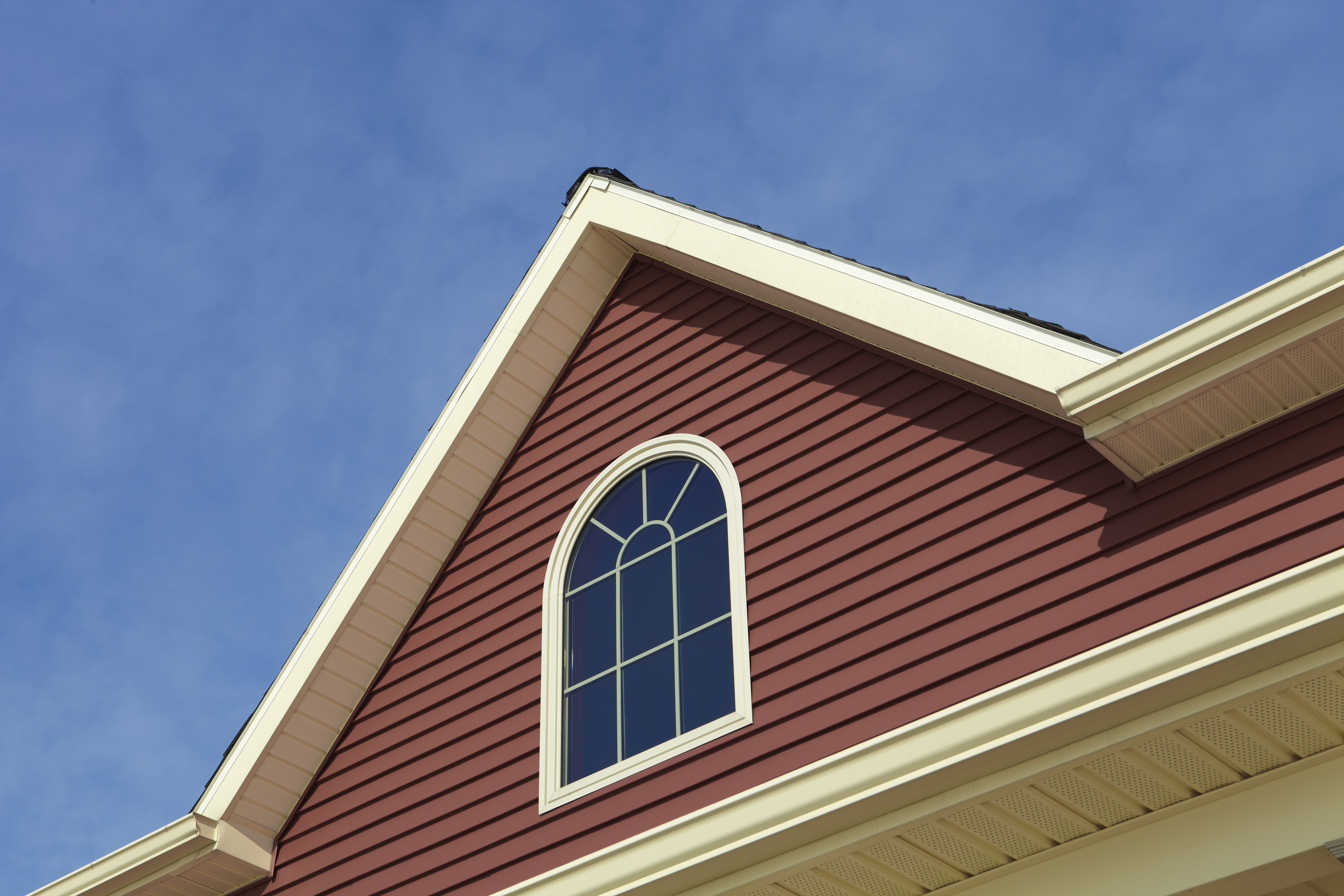 A house with siding against the blue sky