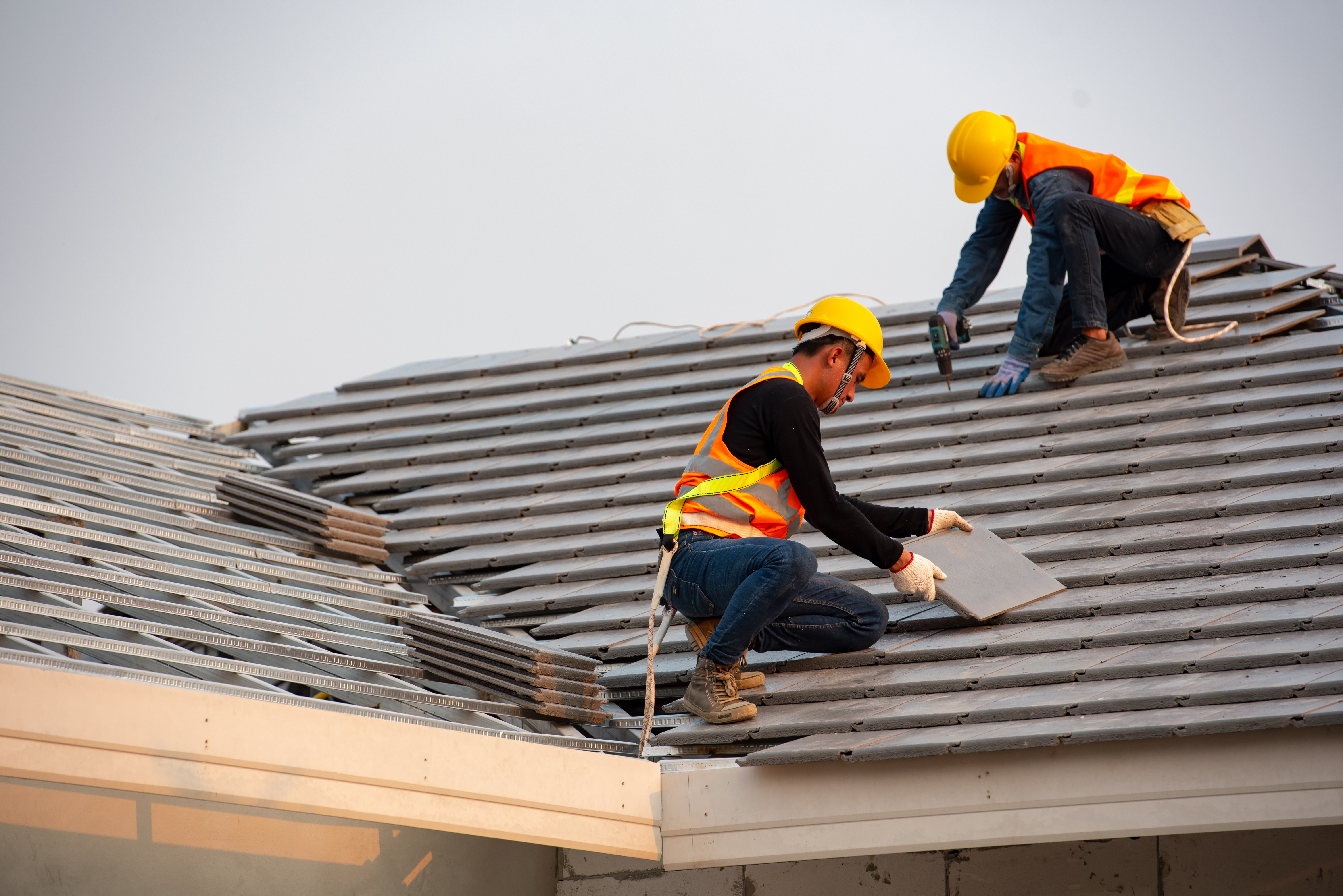 Two professionals replacing a roof