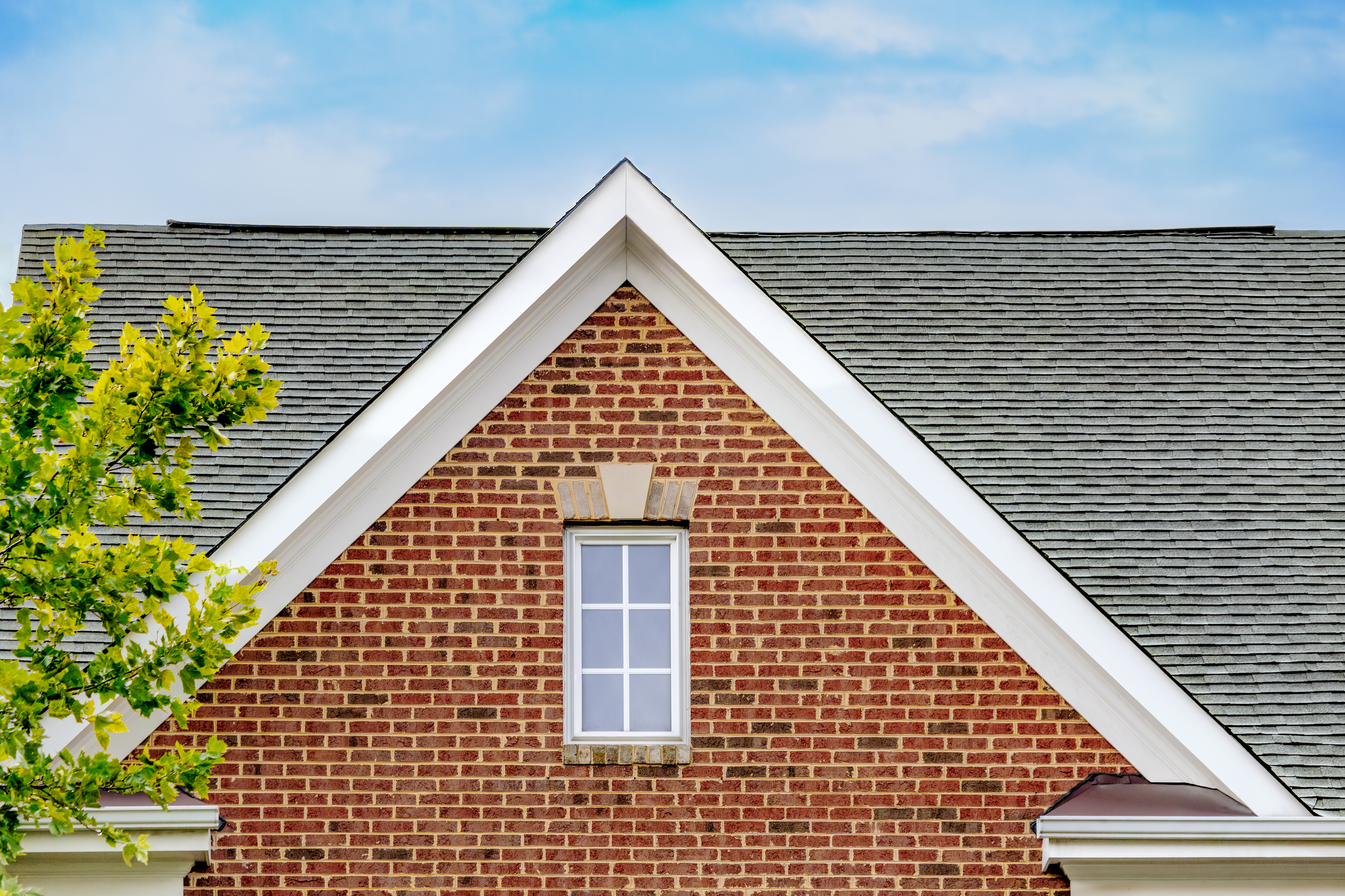 Gable roof on front exterior of brick townhouse 