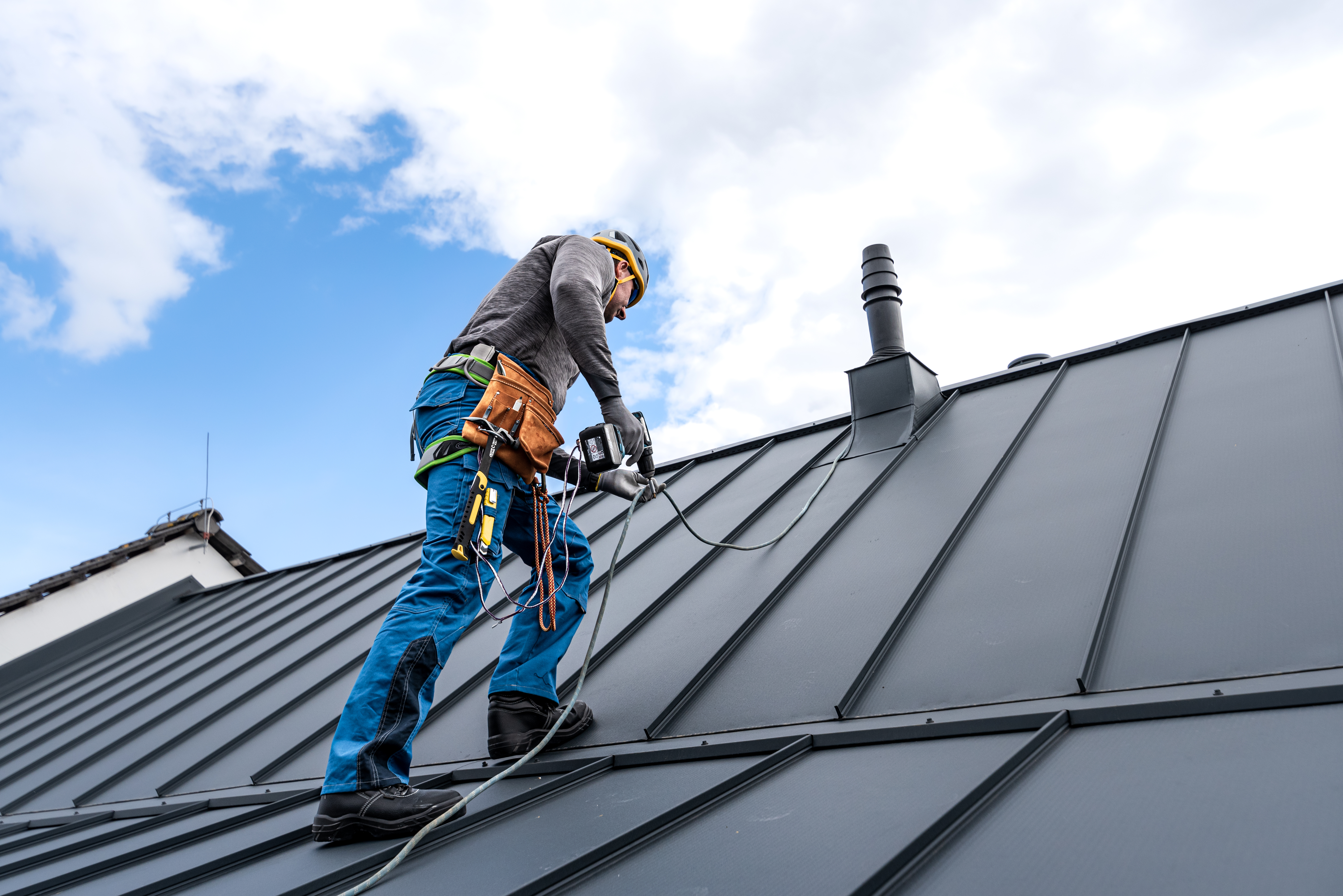 Roofer installing a standing seam metal roof   