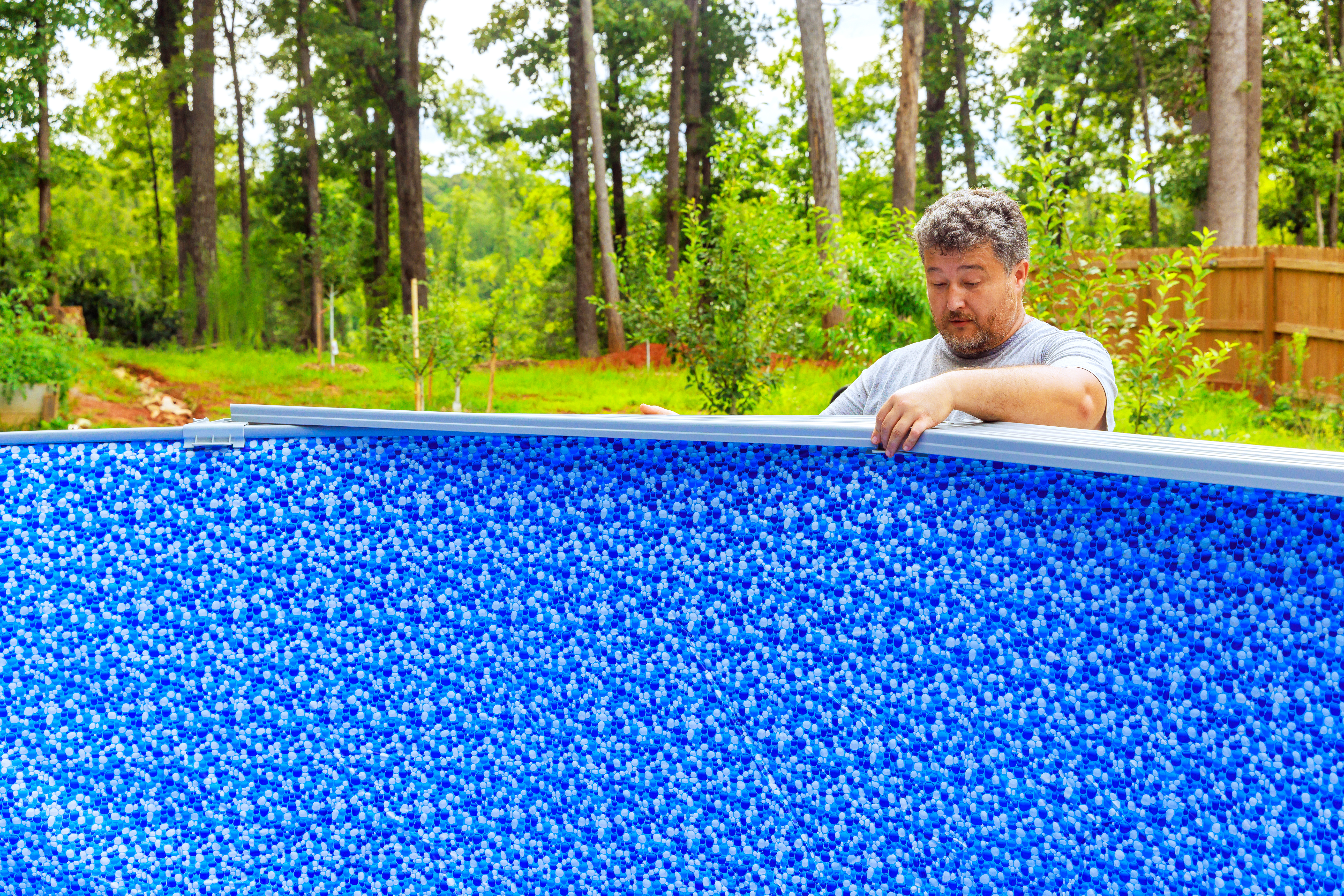 Worker installing pool liner in an above-ground pool