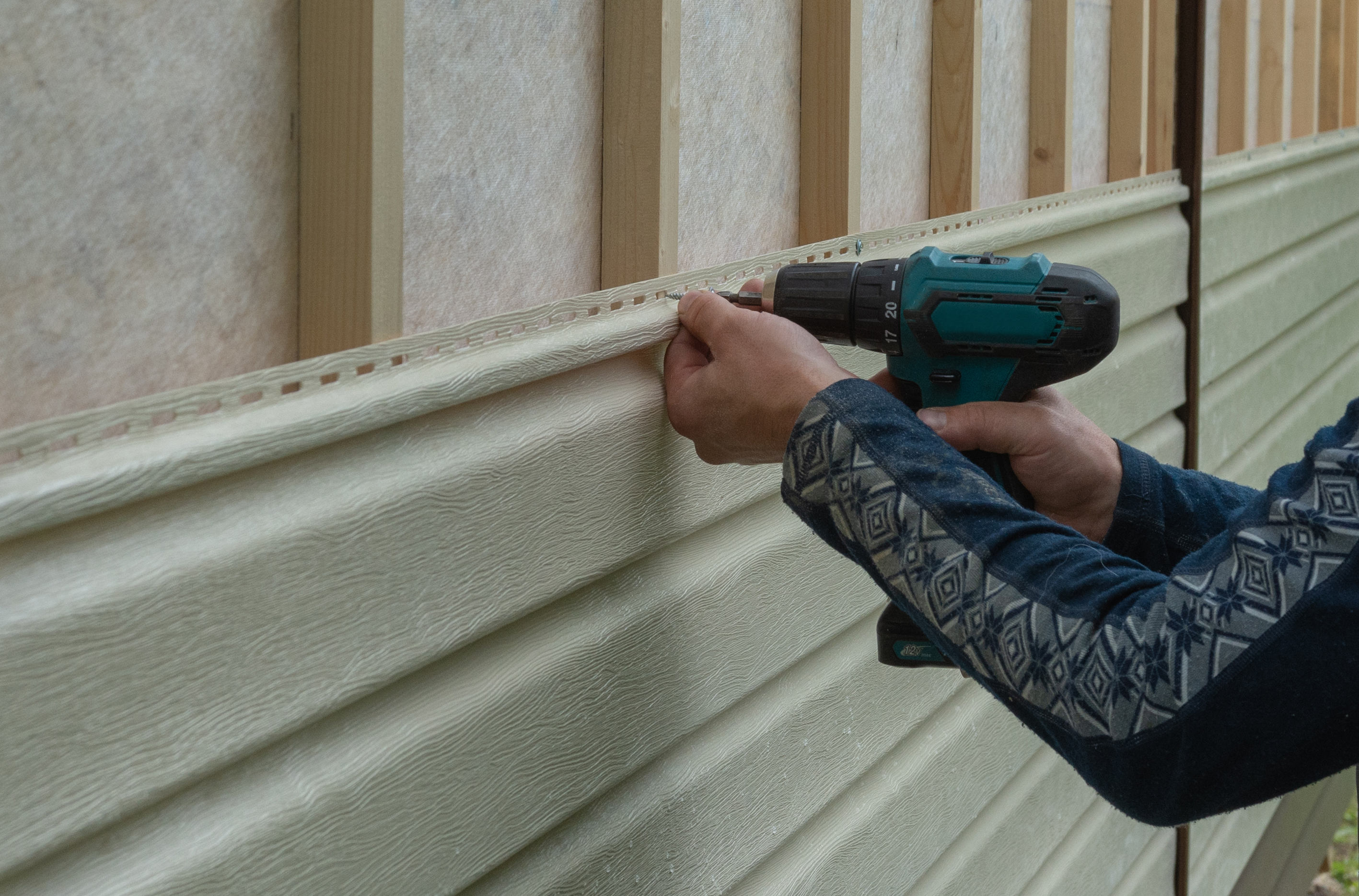 Worker installing siding panels
