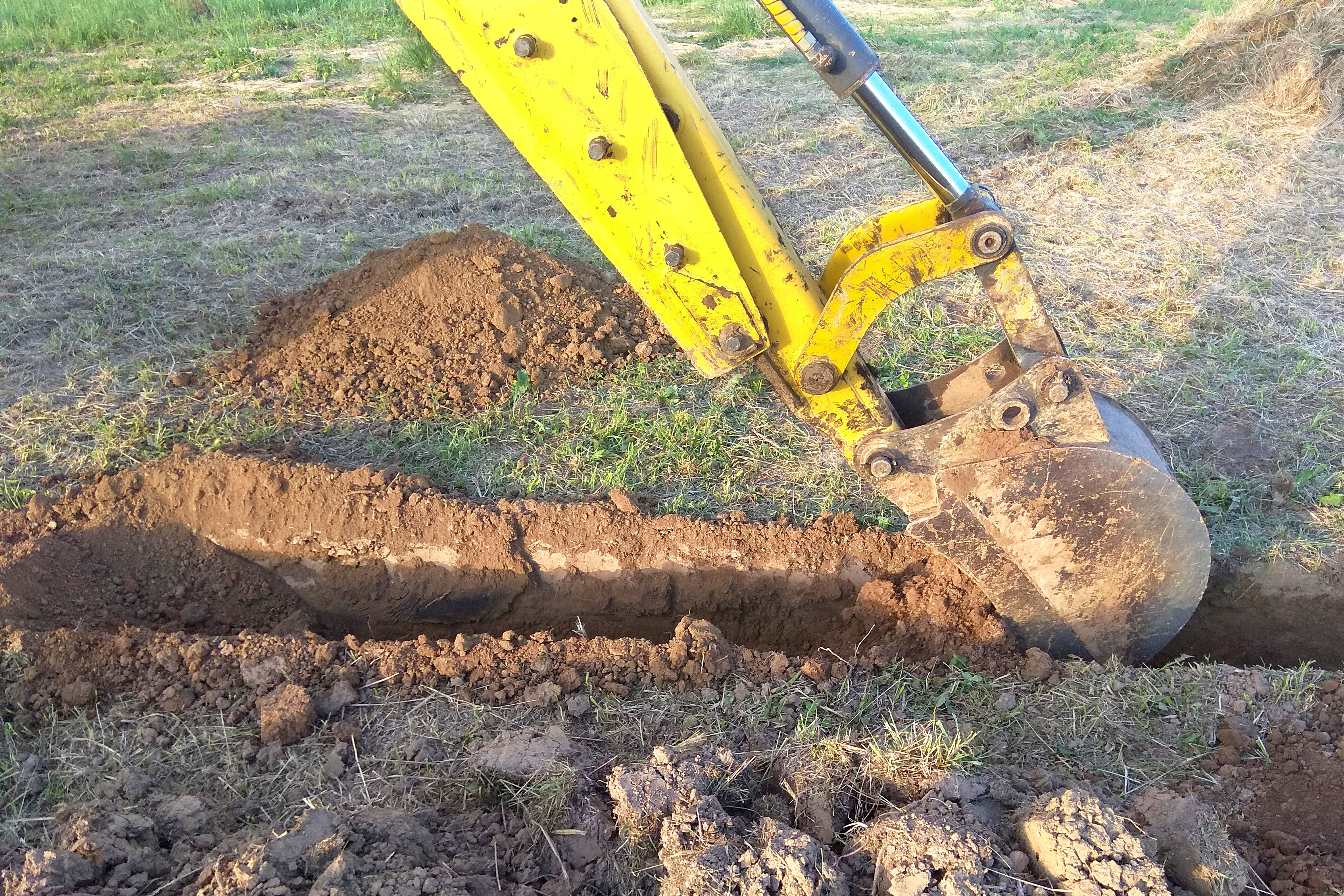 Excavator digging a trench for a main water line