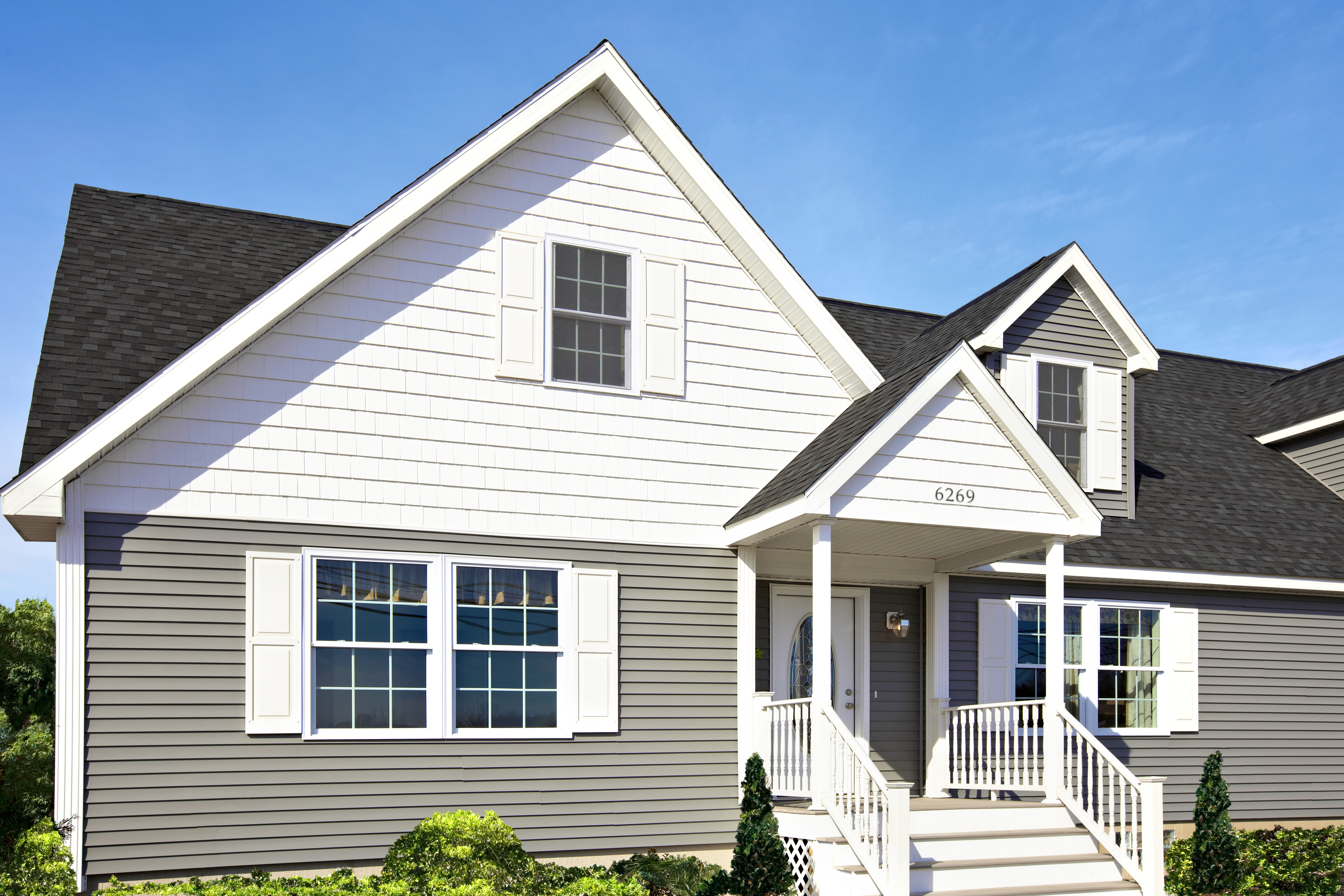 House with gray and white fiber cement siding and window shutters