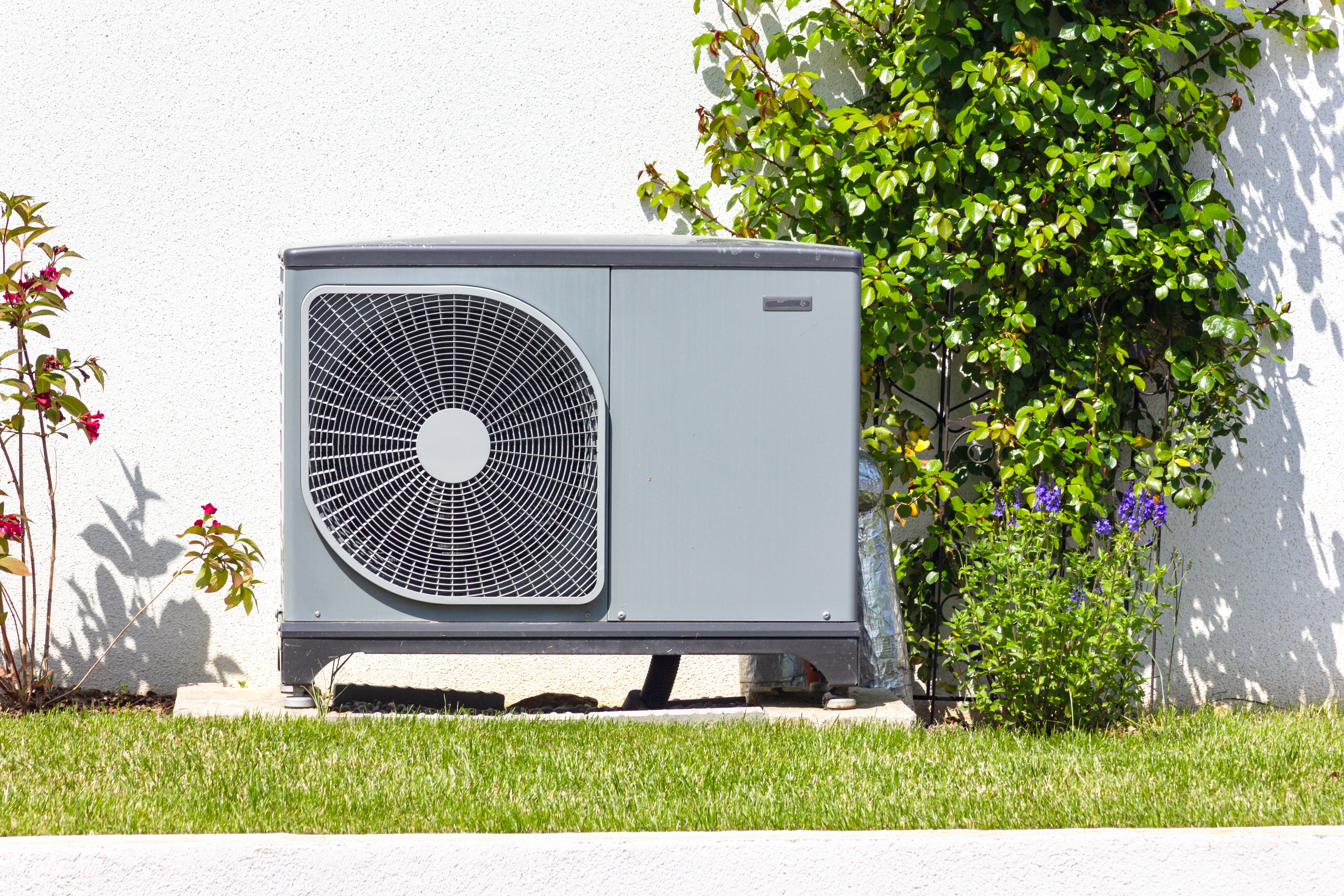 Heat pump sitting on a concrete slab in the yard