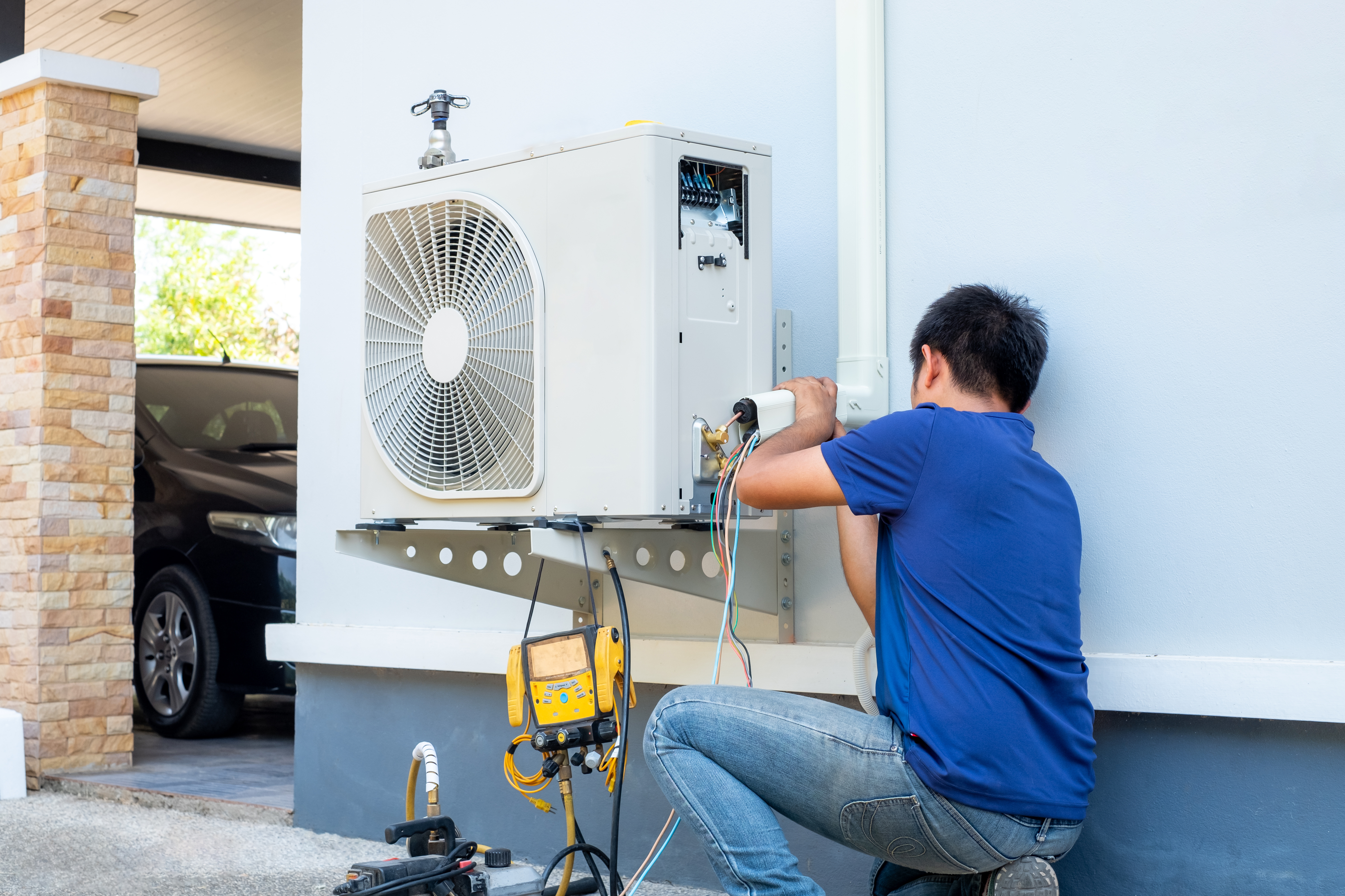 technician installing ac outside home