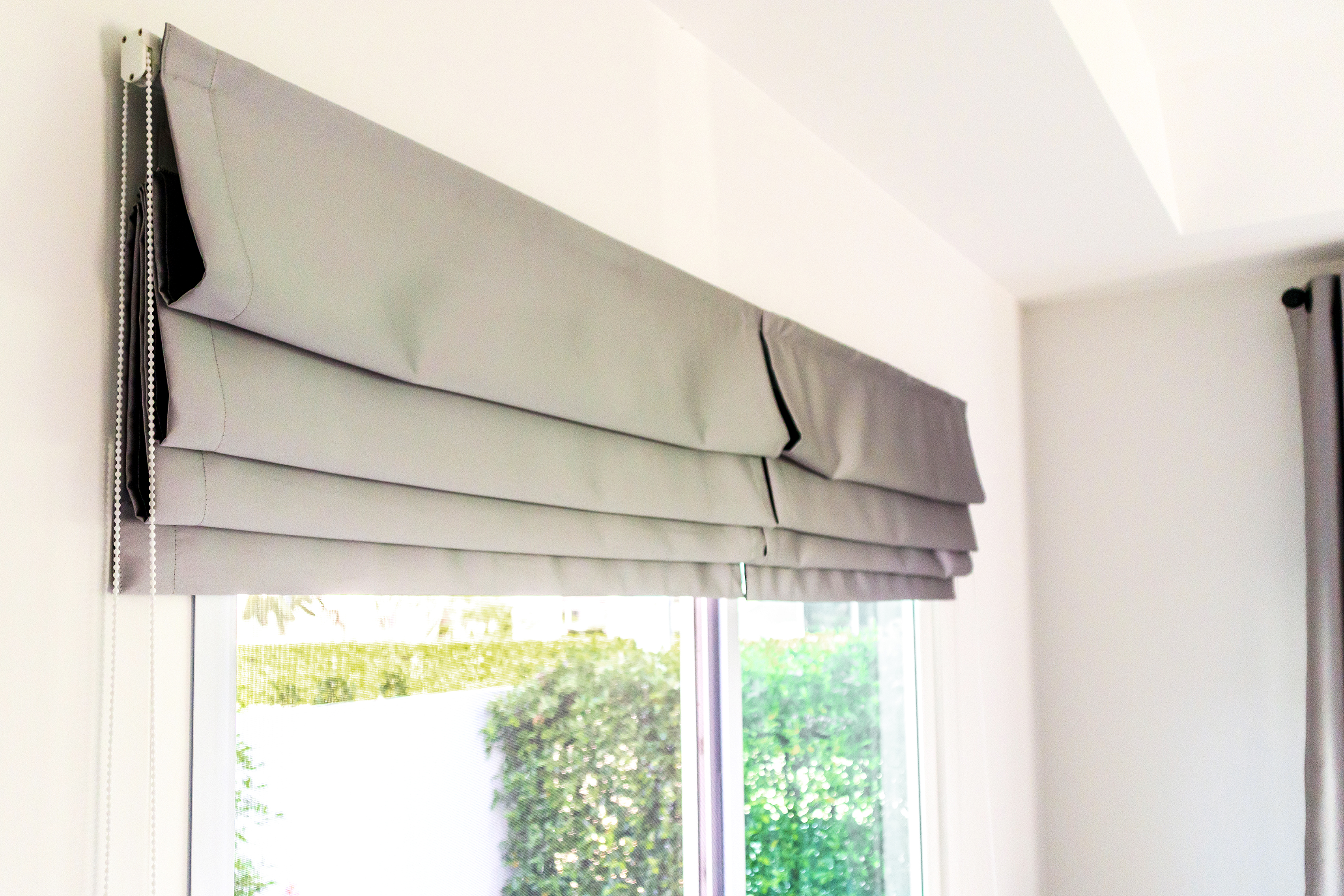 Gray roman blinds installed in the room