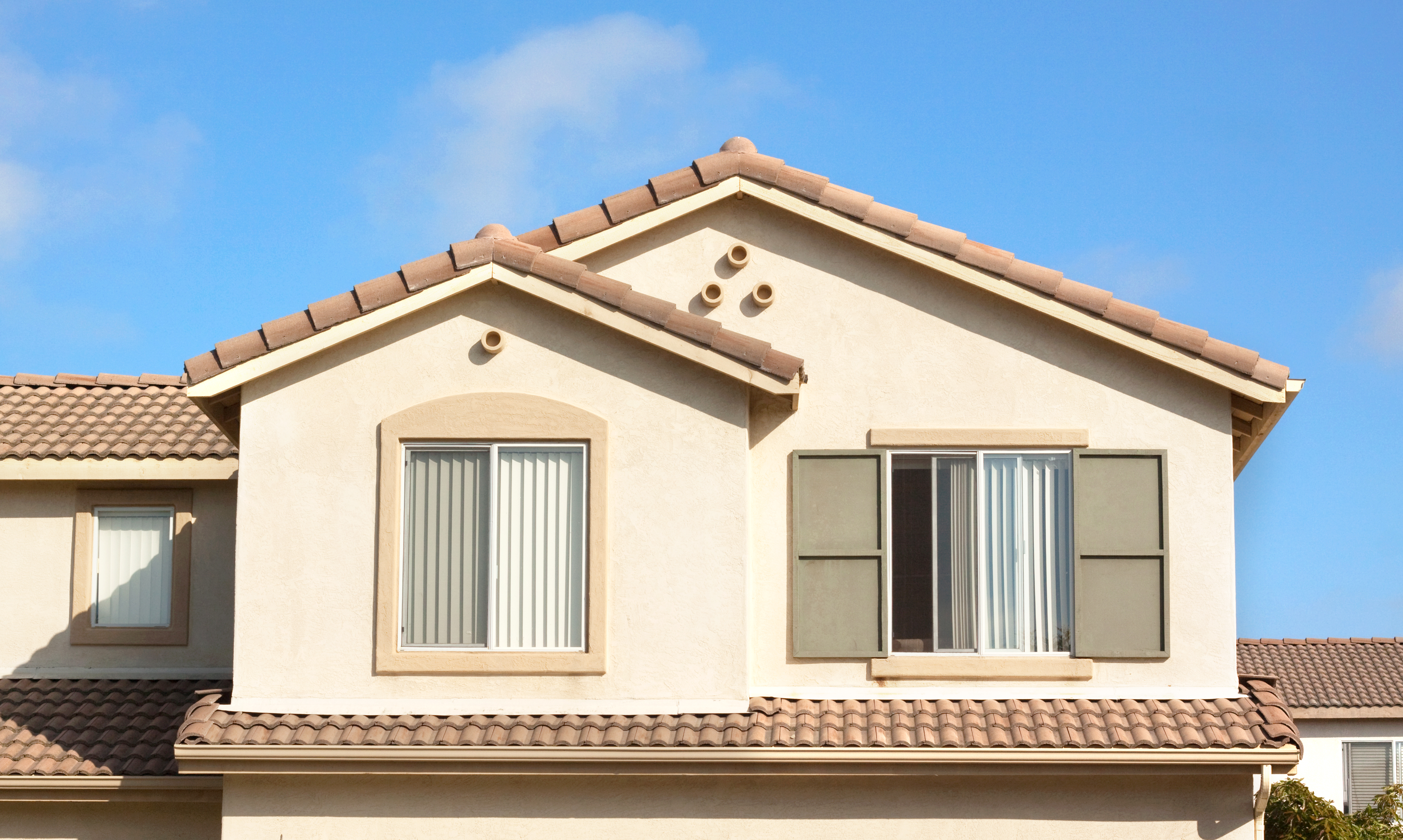 Windows installed on the upper level of a stucco house