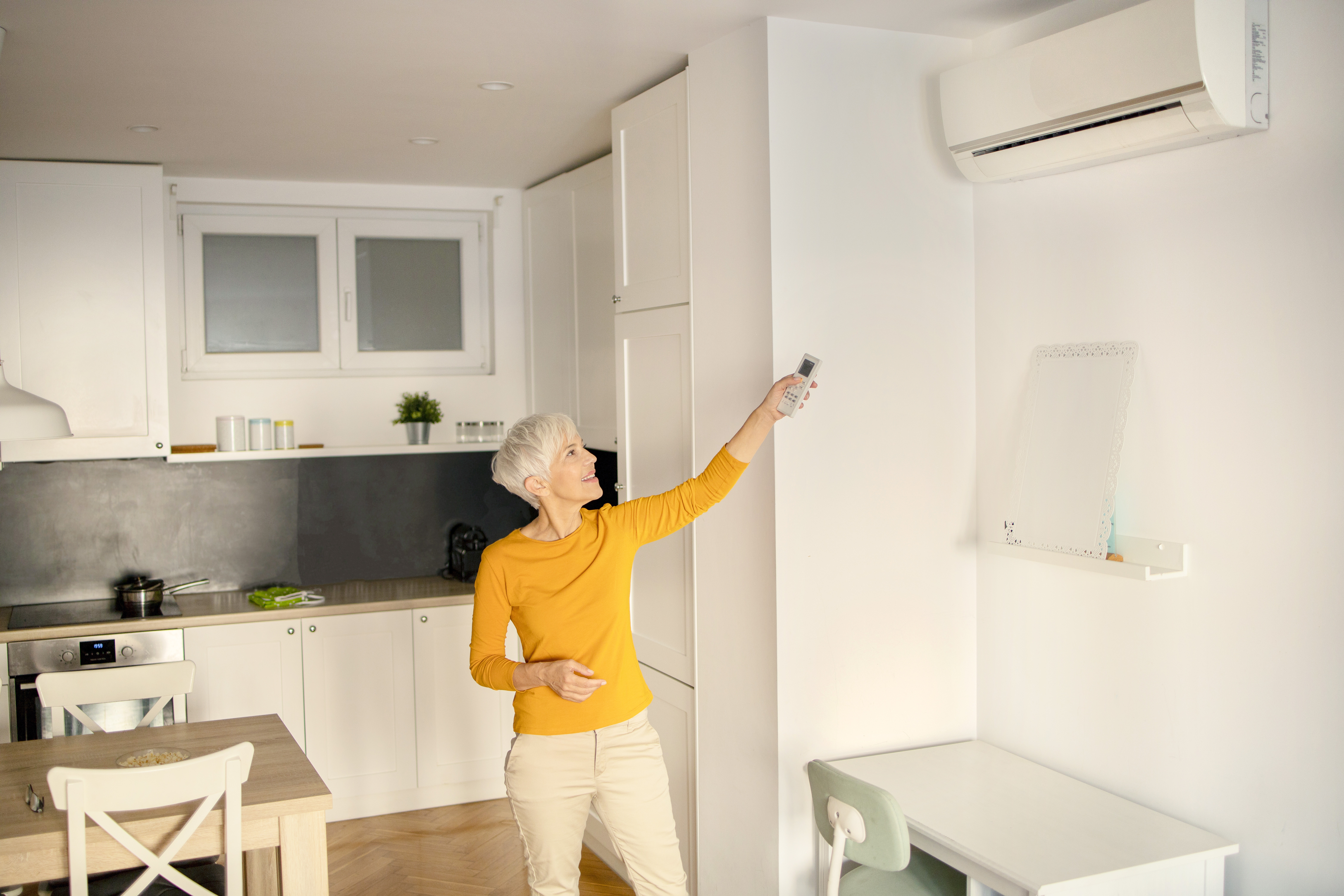 Woman using a remote to turn the mini split AC on