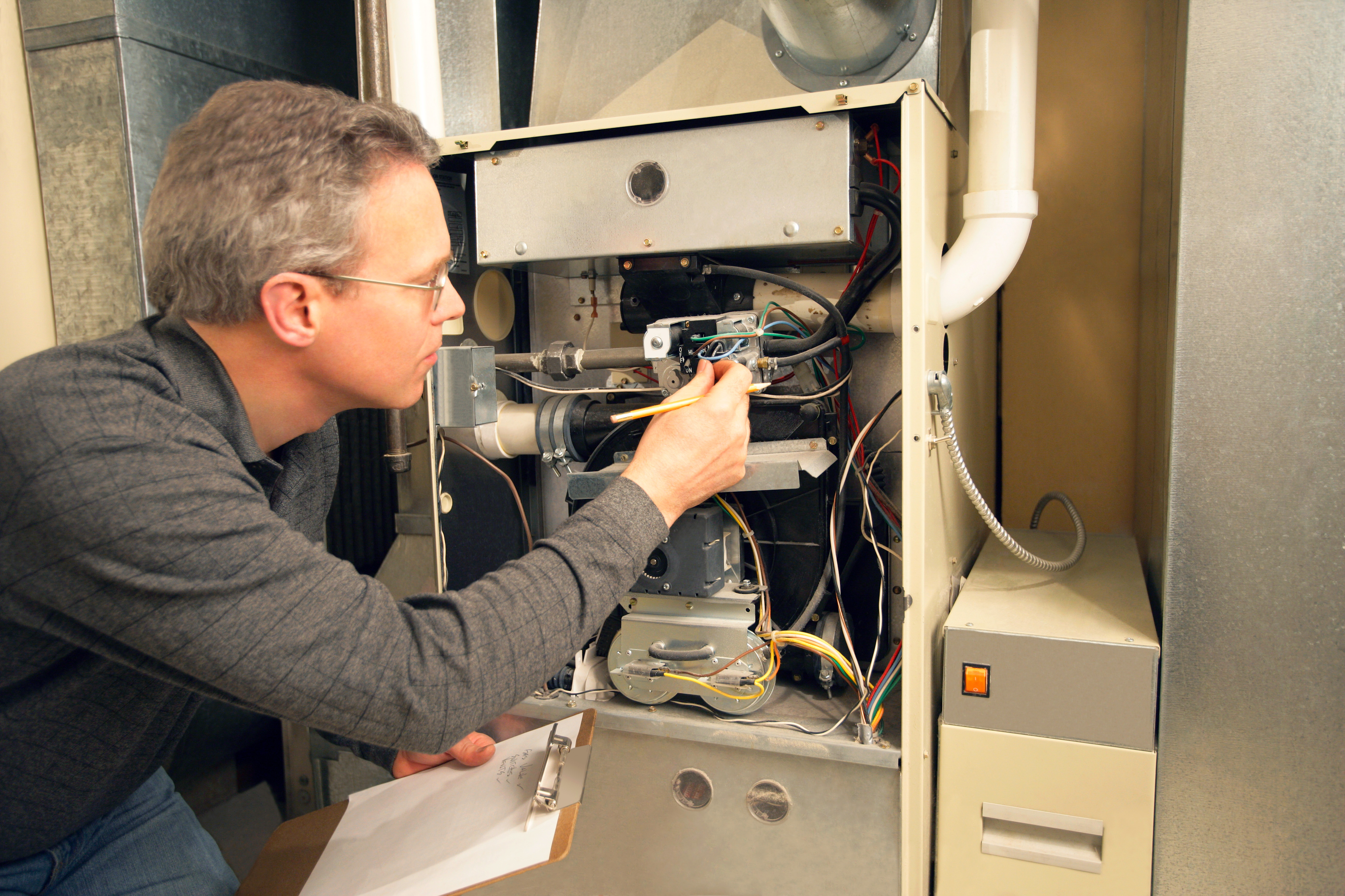 Technician inspecting the furnace in the basement