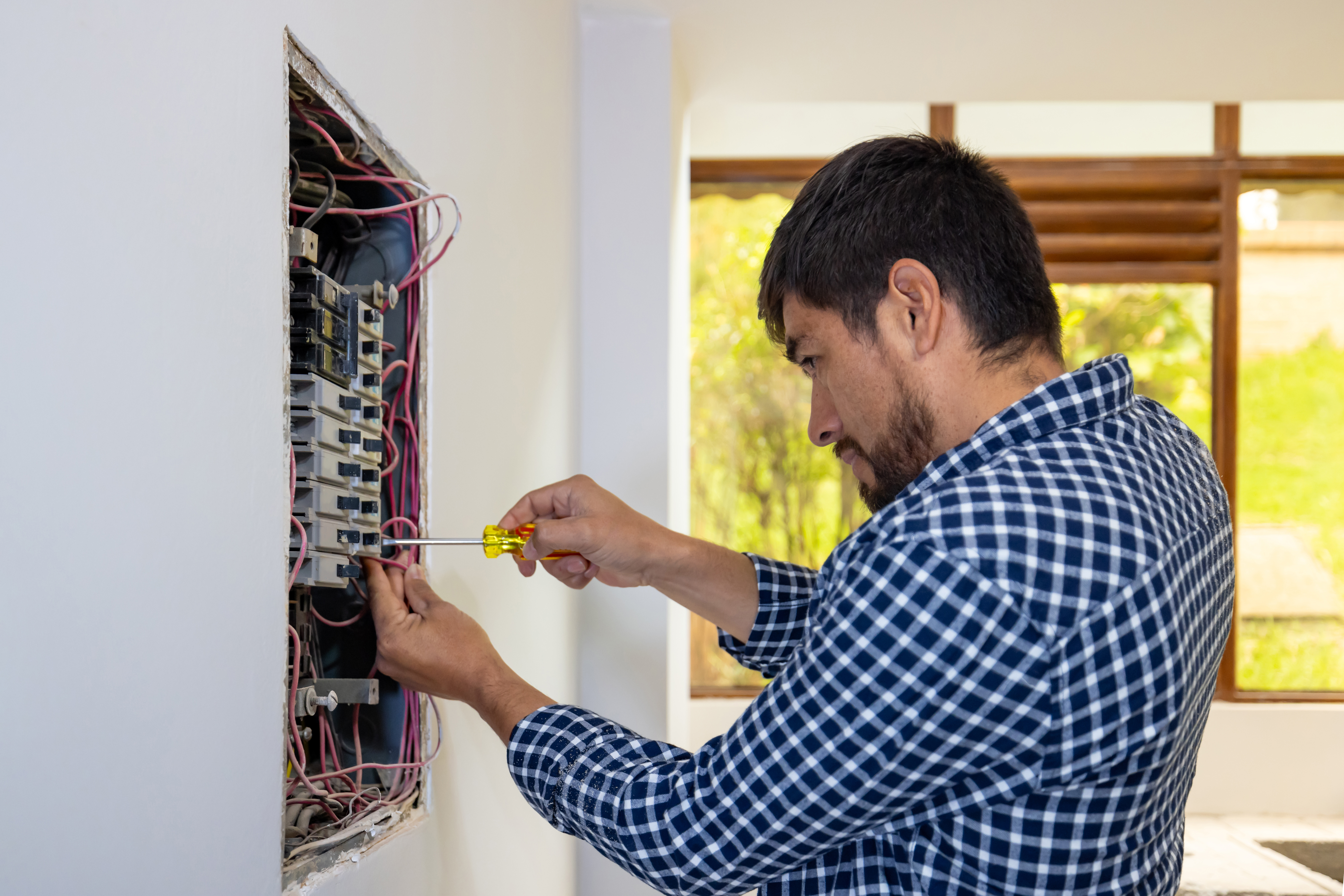 Electrician installing a fuse box 