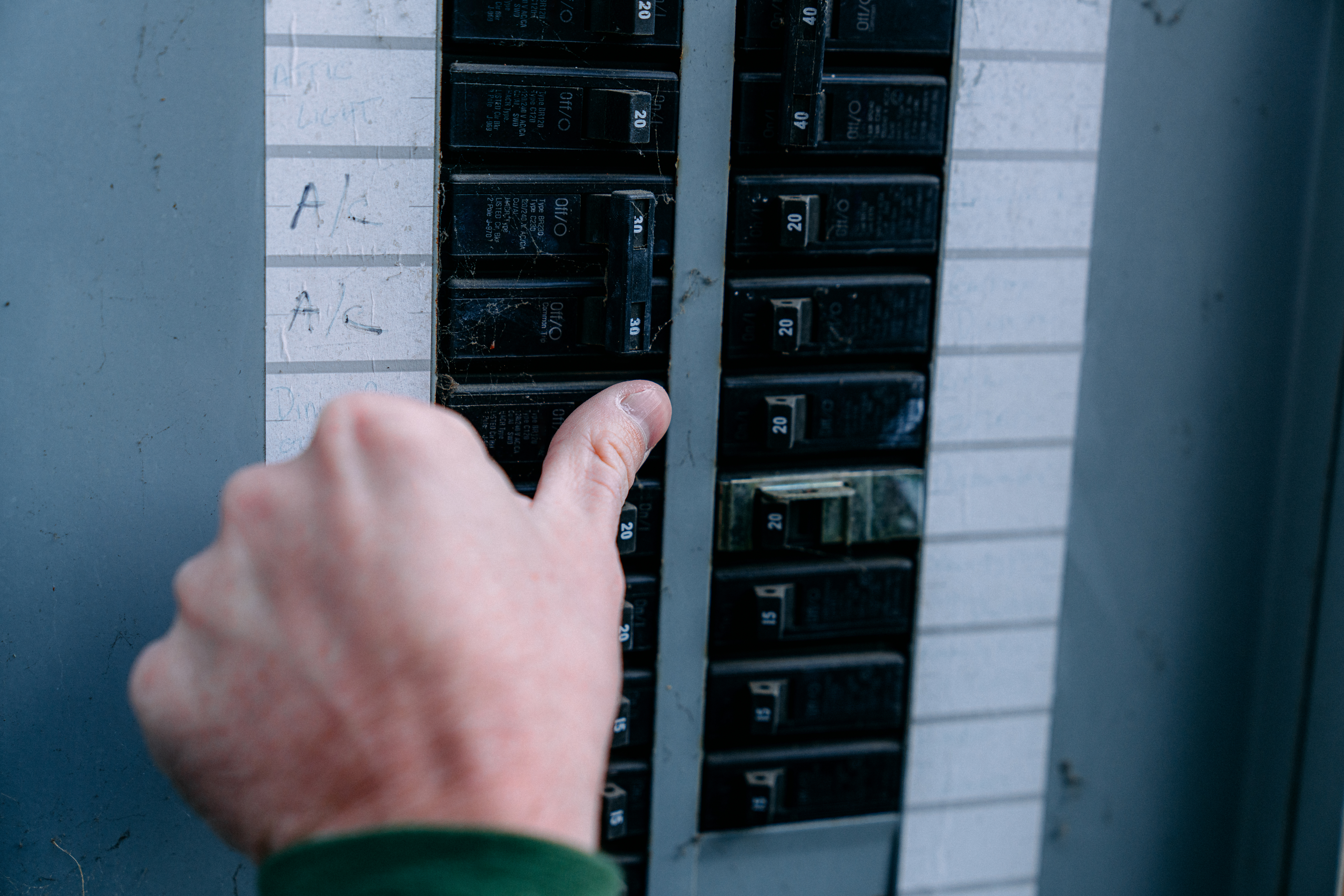 Man turning on a circuit breaker