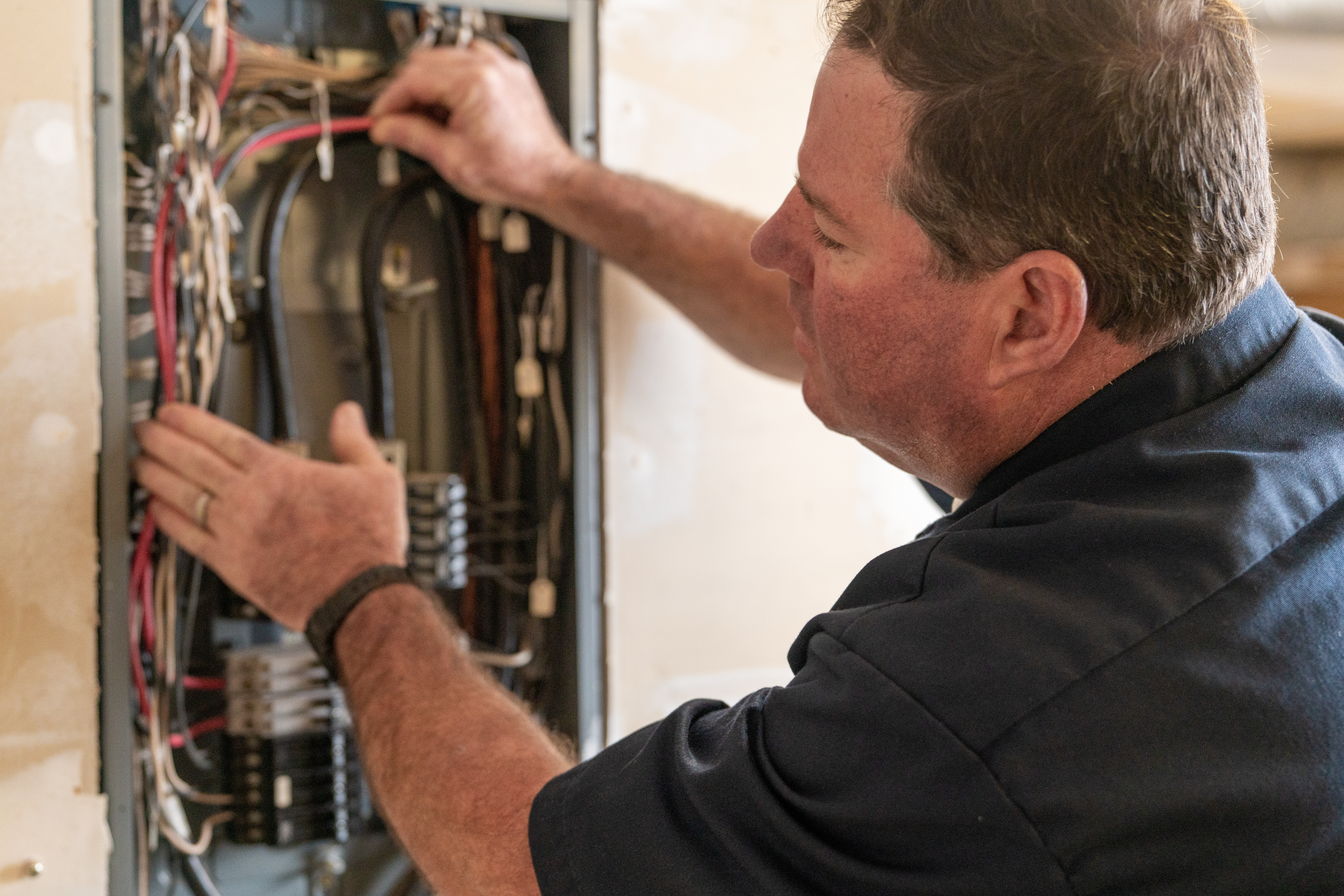 Electrician working on circuit breaker box