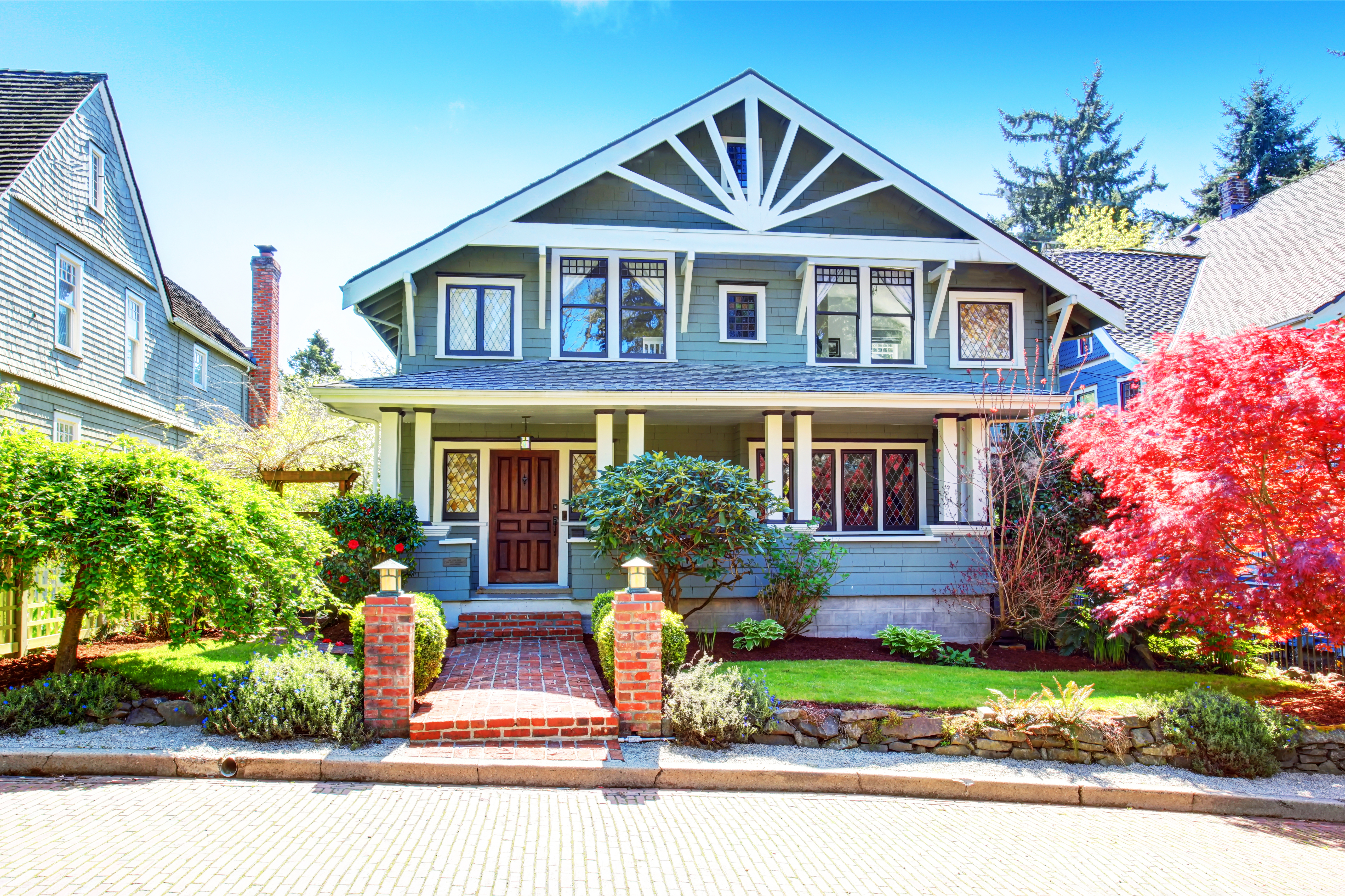 Craftsman style house with blue siding and a brick walkway   