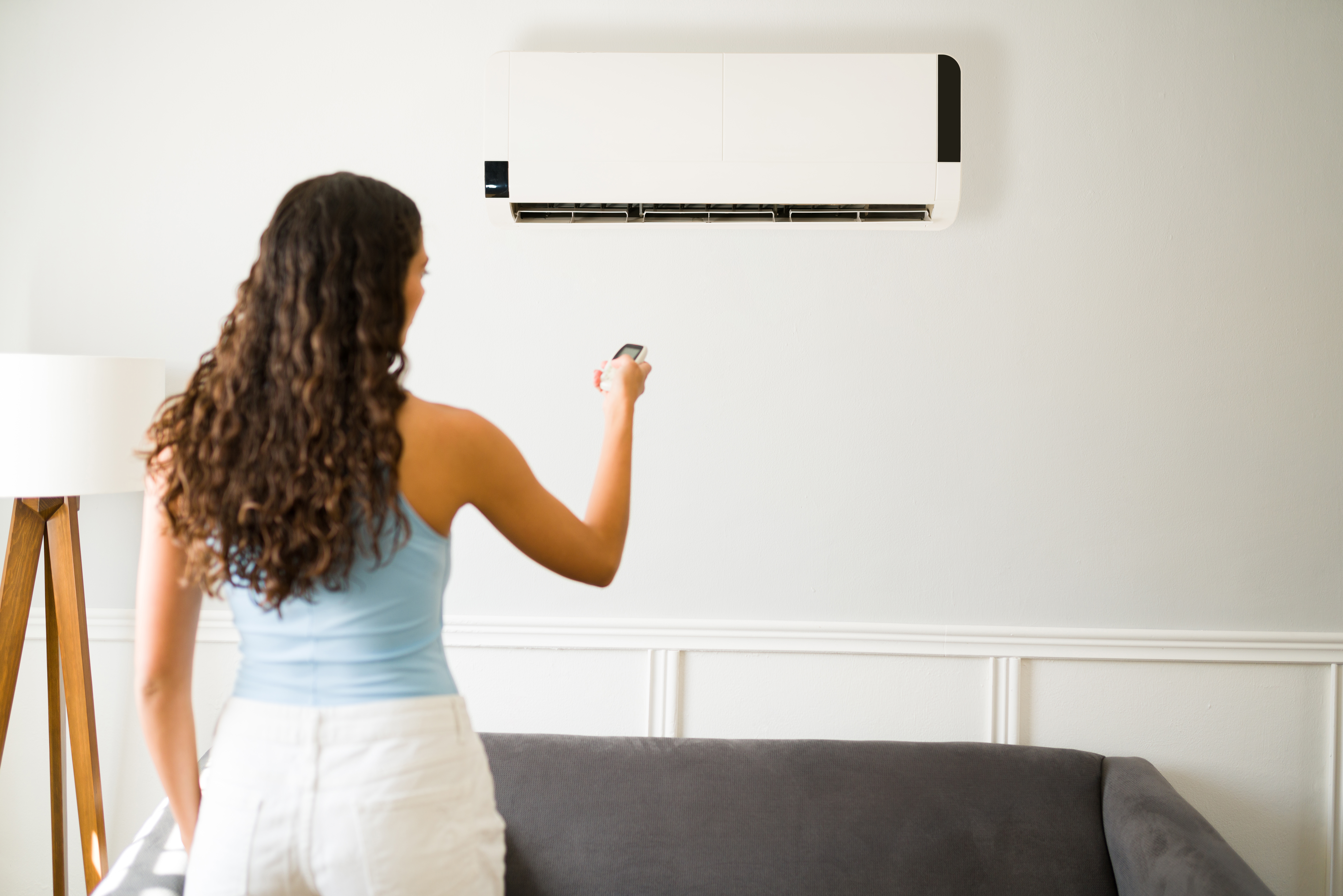 Woman adjusting temperature on a mini-split system