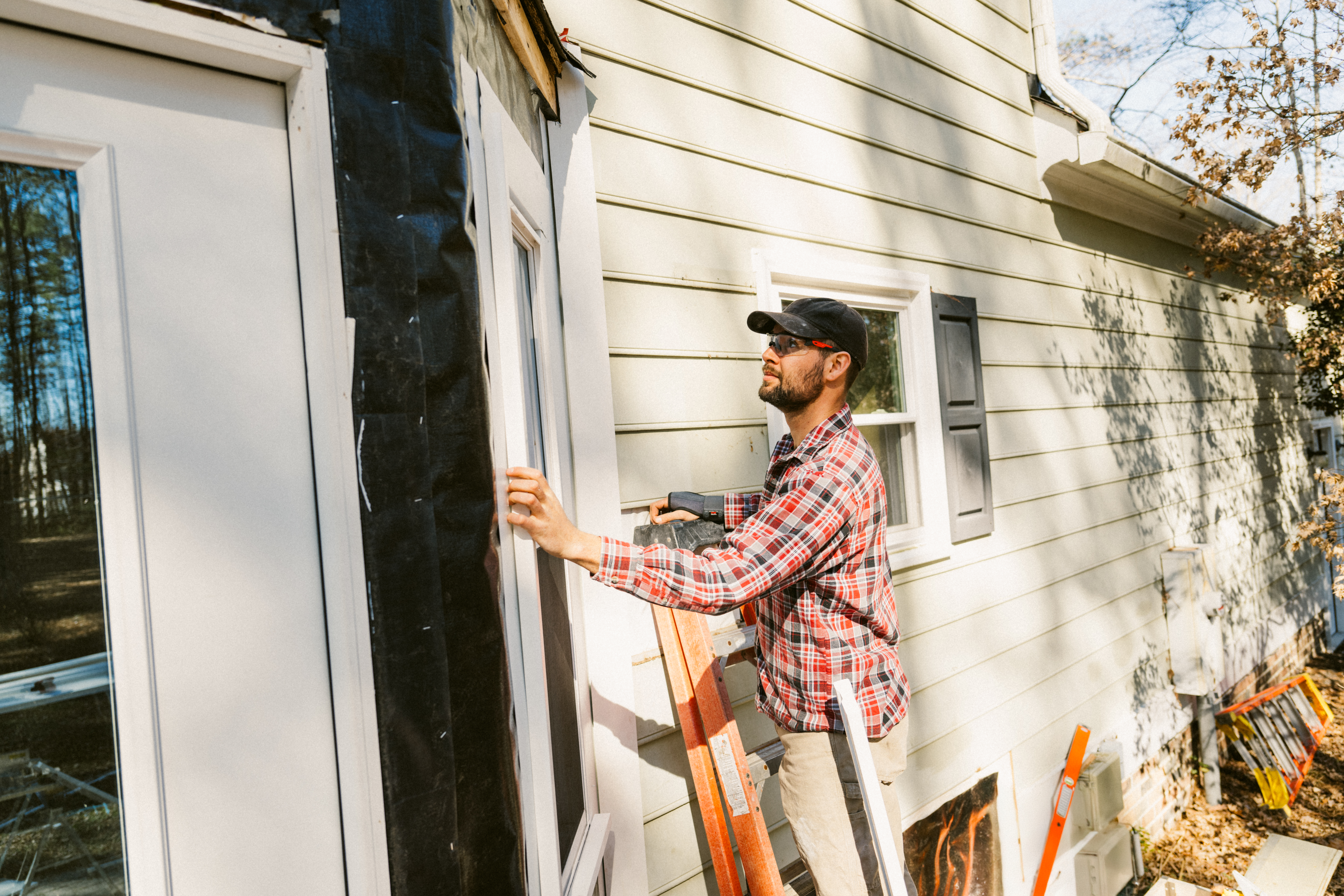 Construction worker repairing a colonial style house siding