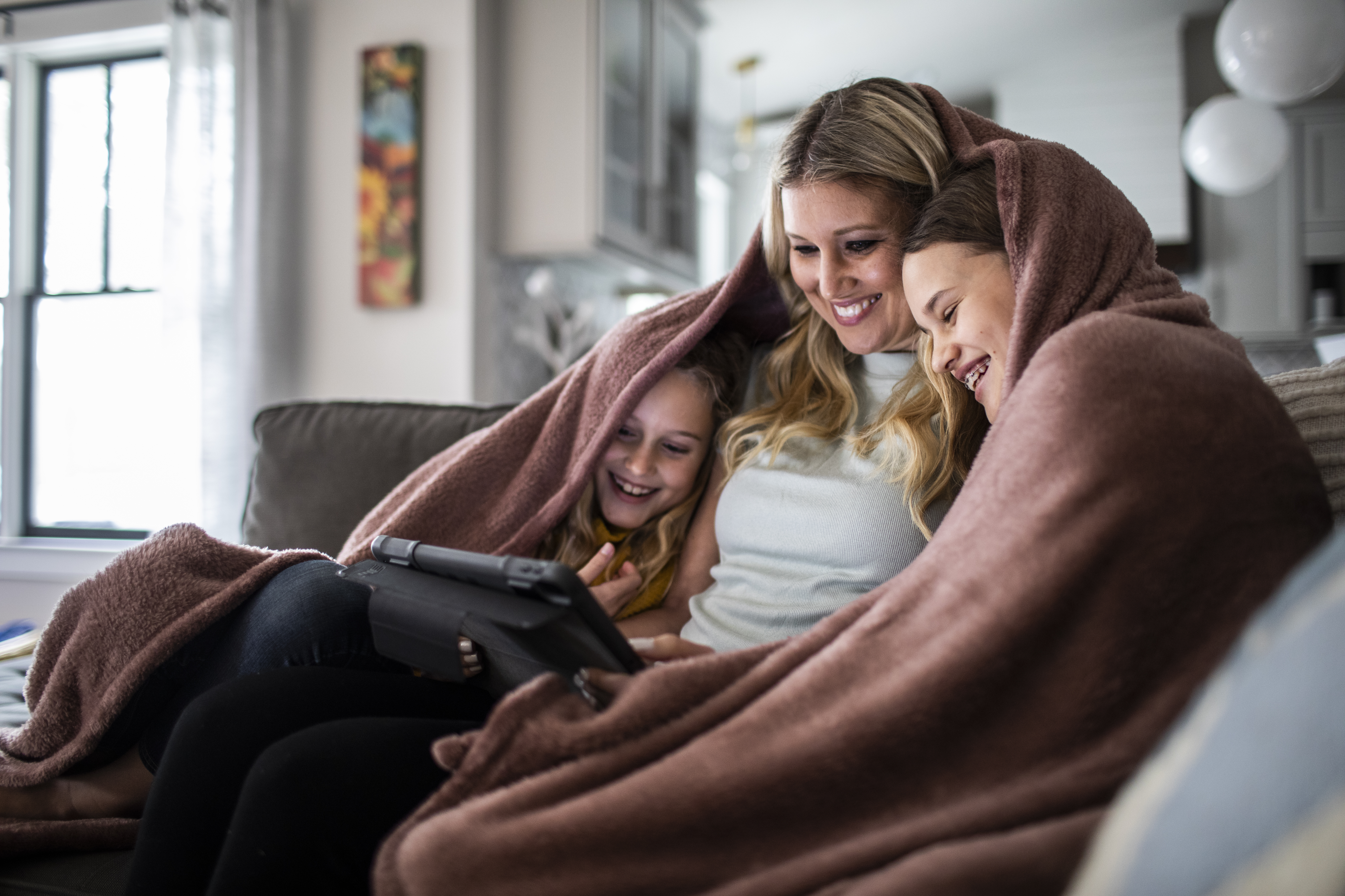 mom and children cozy under a blanket