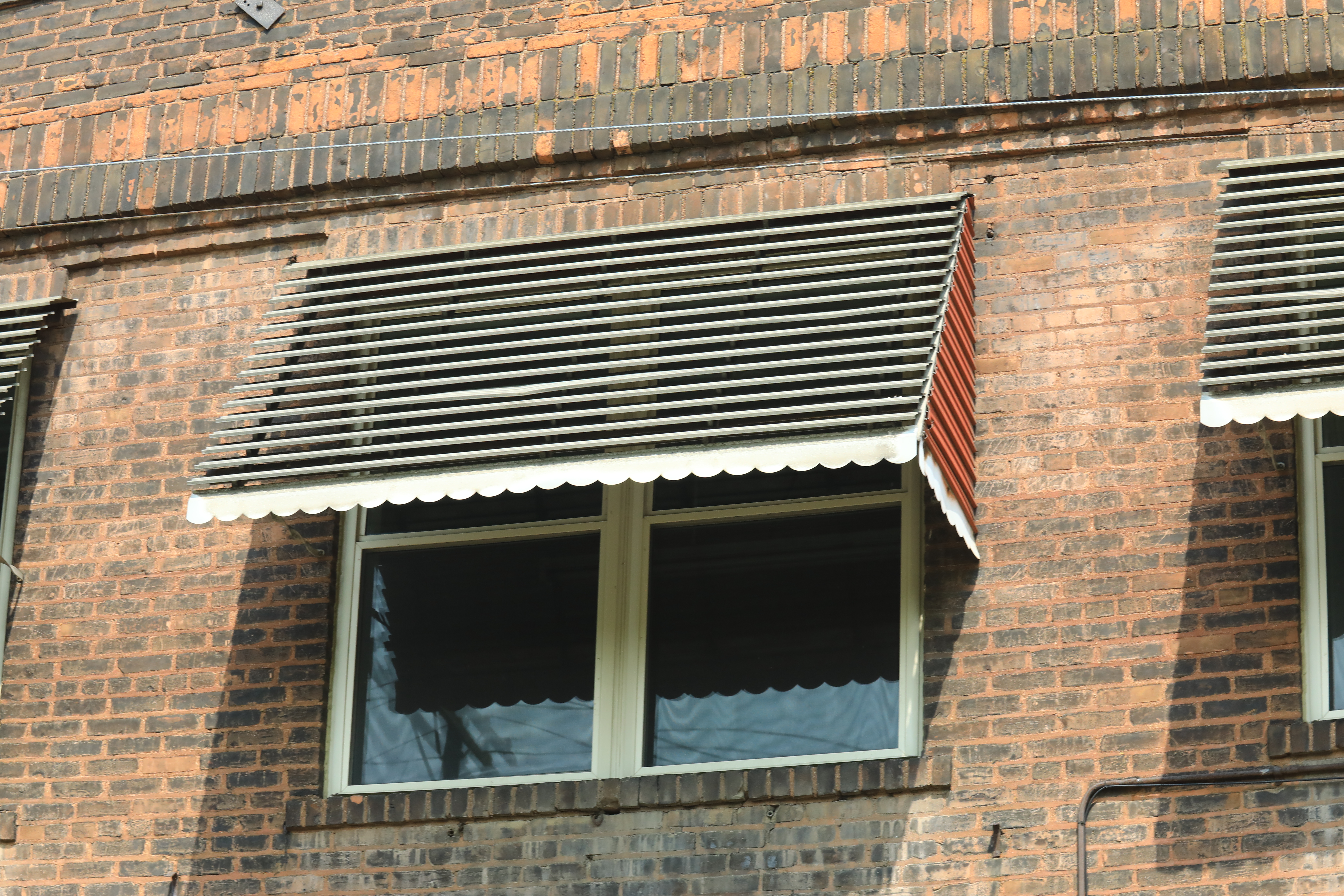 An awning window on a brick house