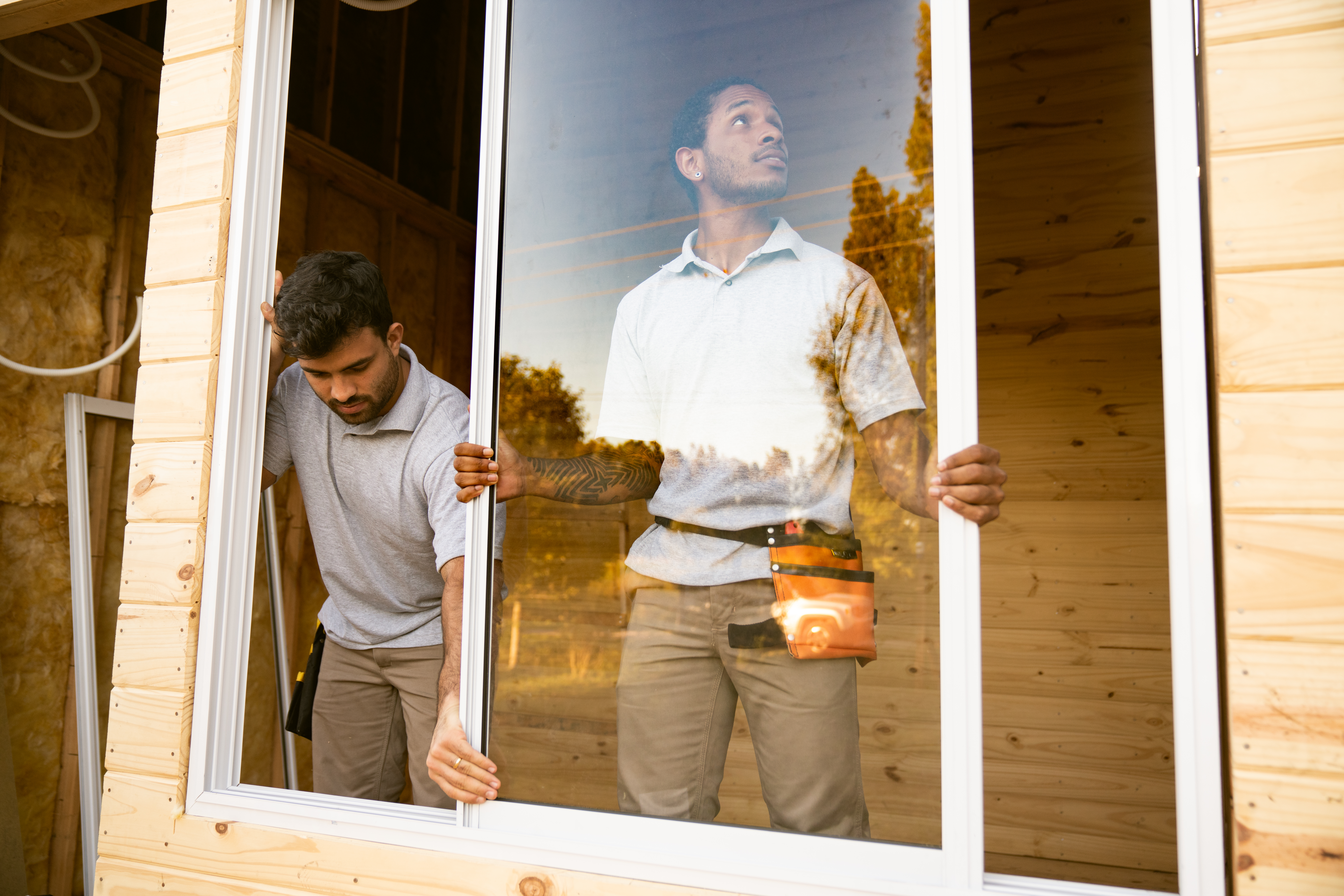 Two workers installing a new window