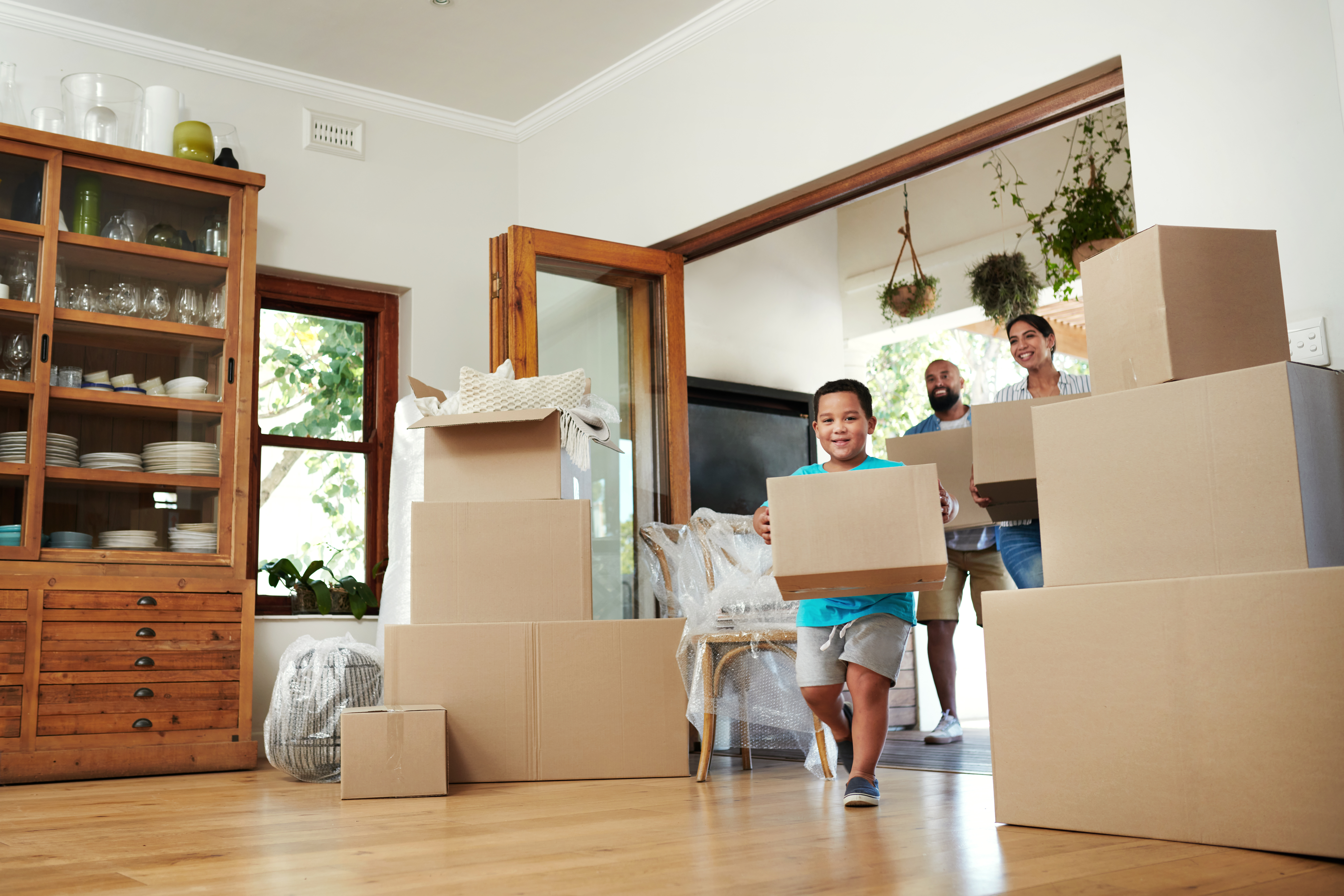 Family walking into new home with boxes