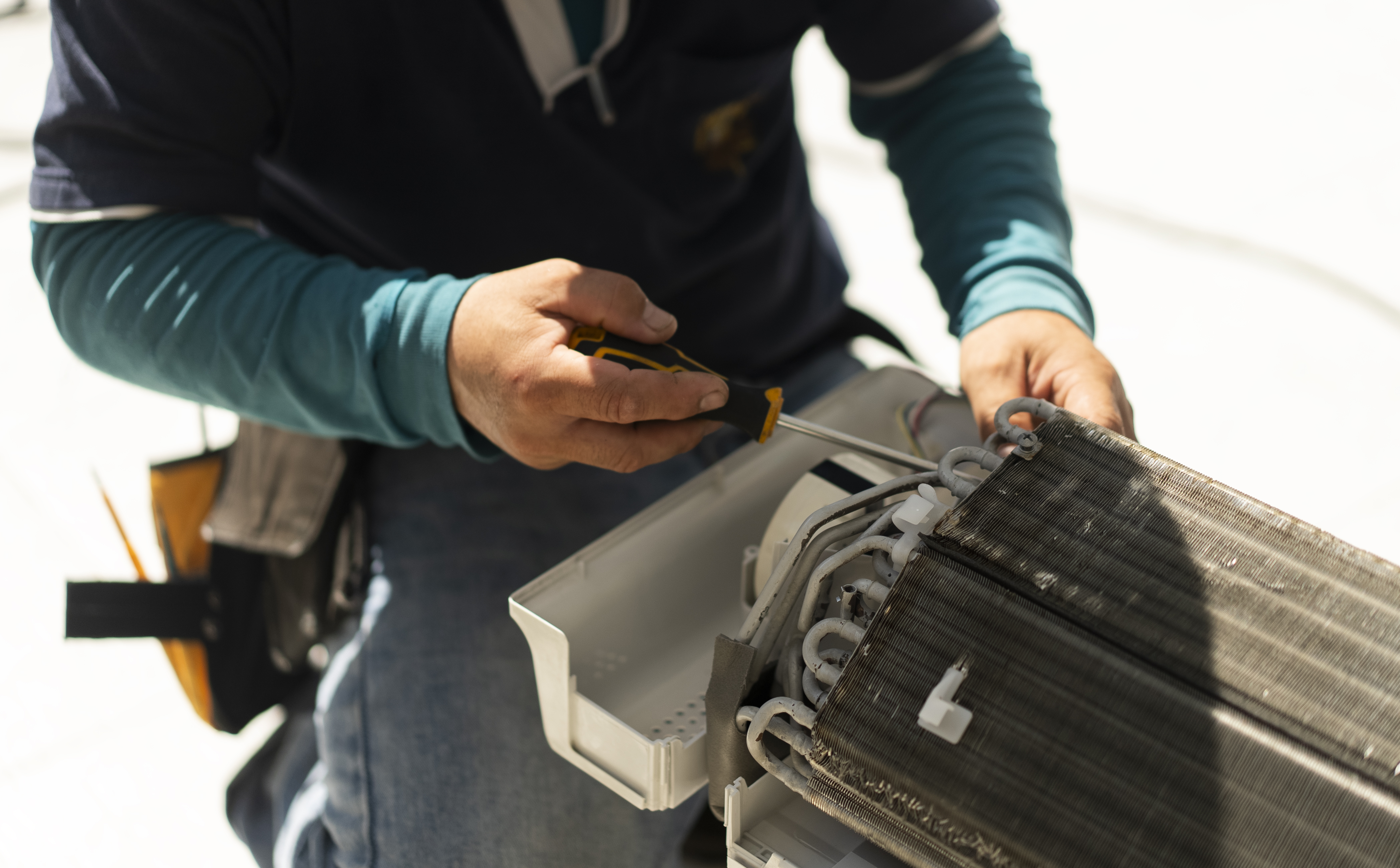 man repairing ac coil