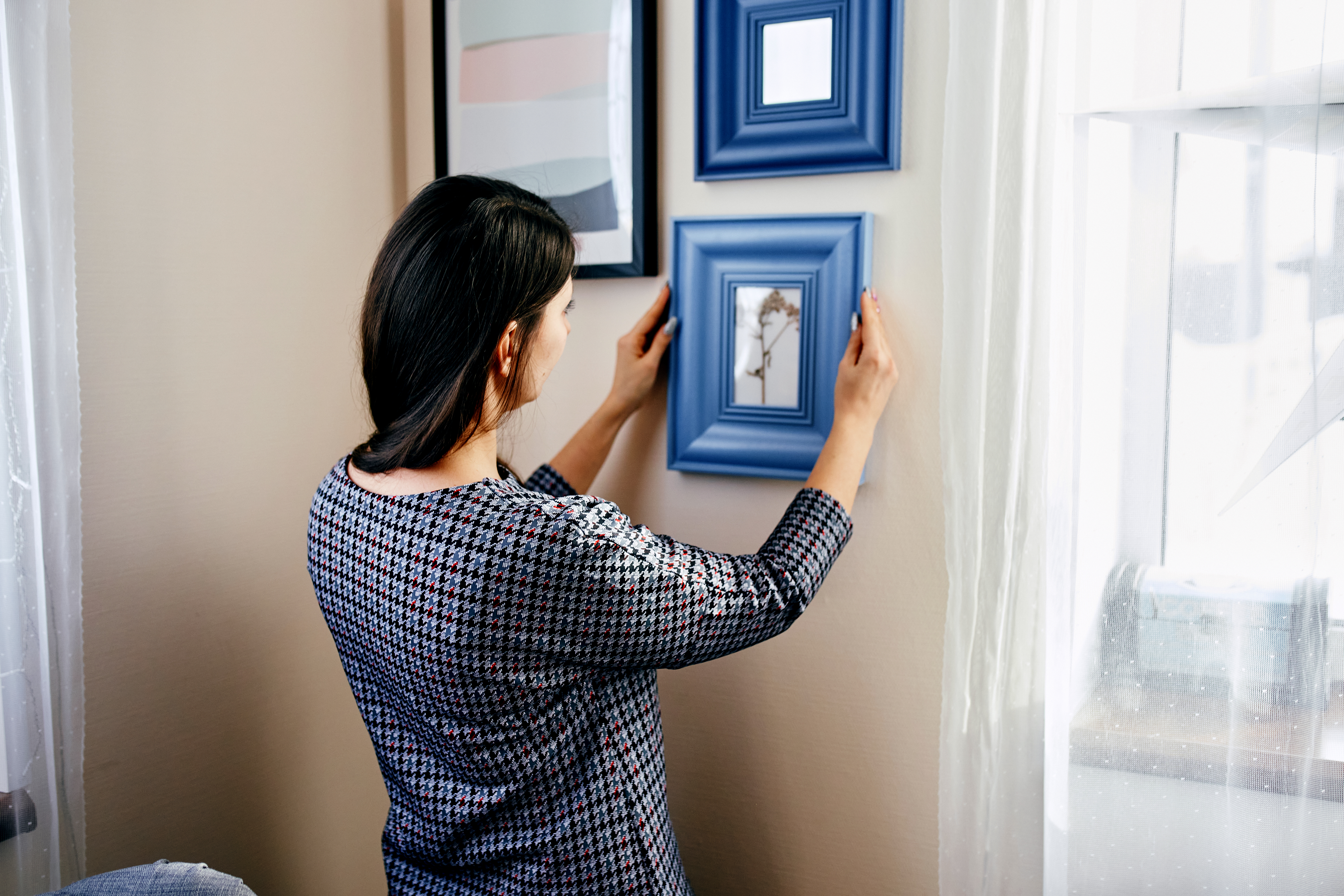 woman spacing out picture frames